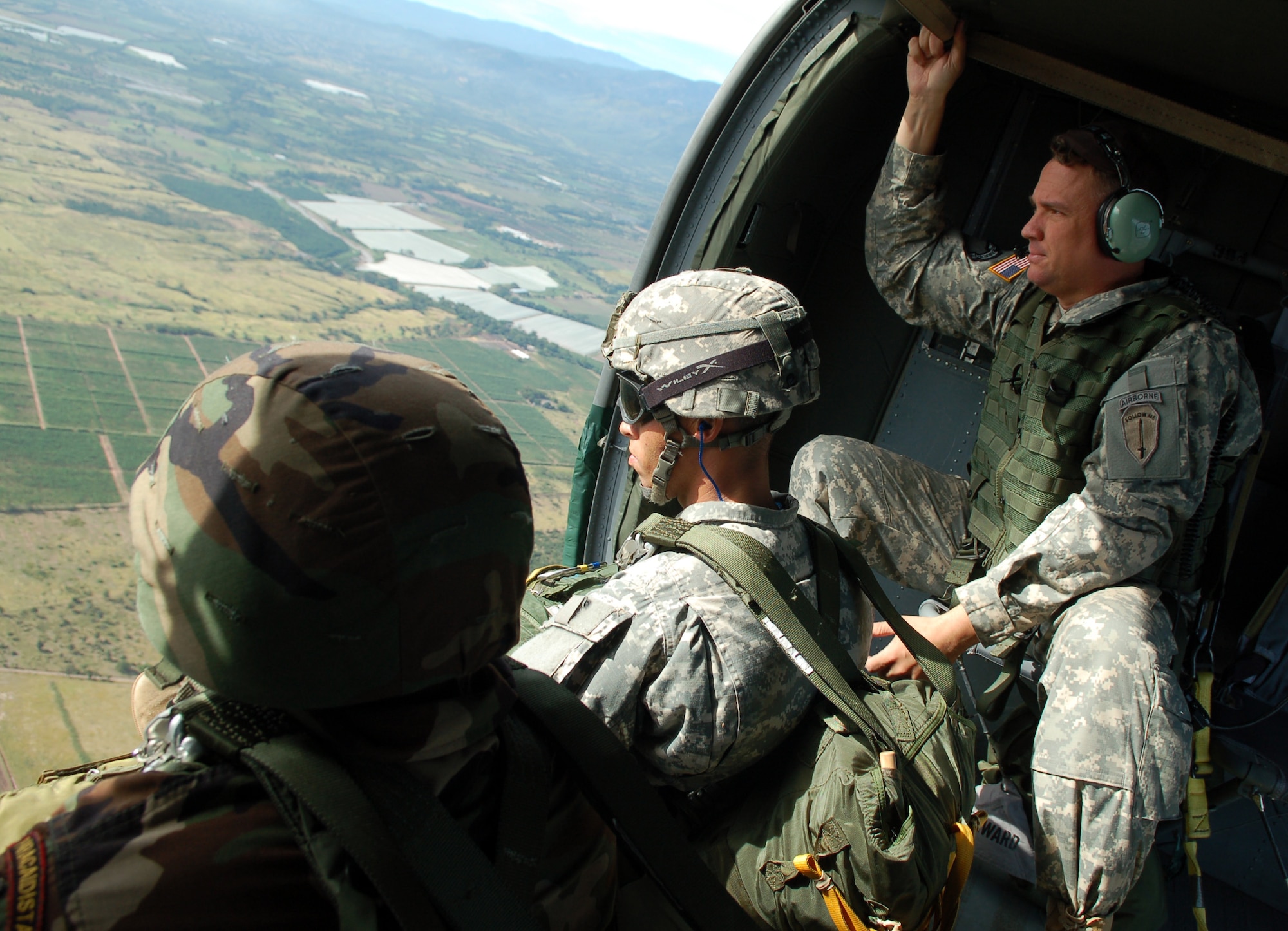 SOTO CANO AIR BASE, Honduras – Army Soldiers and a Honduran Paracaidista wait for their signal to leave their UH-60 Black Hawk helicopter flying over Soto Cano’s Iguana Drop Zone during a multinational jump Nov. 30.  The jump was the opening event of Caminata de Coroneles, a “camaraderie walk” attended by top military leadership from Honduras and JTF-Bravo in recognition of 39 retiring Honduran colonels.  (U.S. Air Force photo by Staff Sgt. Austin M. May)