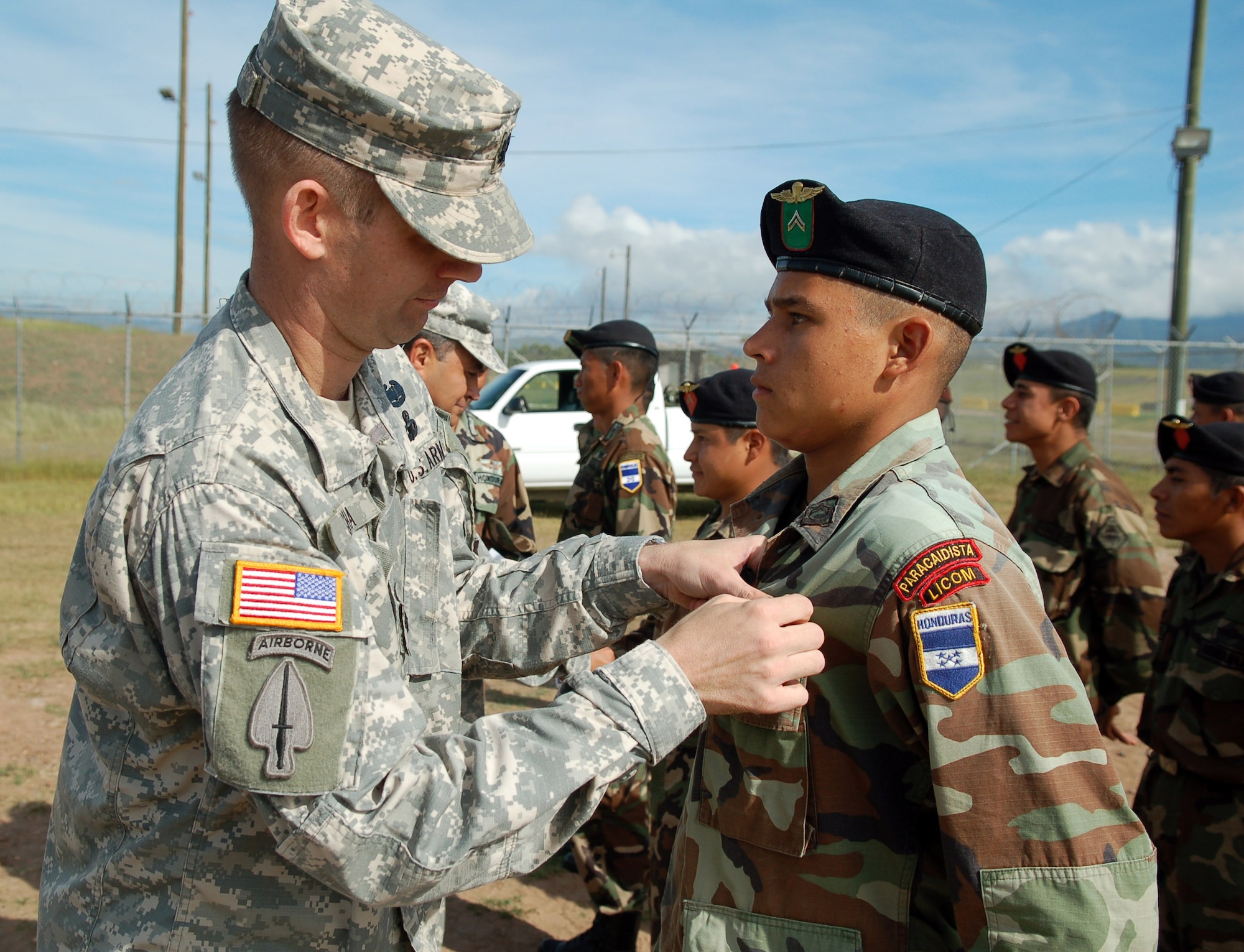 SOTO CANO AIR BASE, Honduras – Army Lt. Col. Gregory Jicha, Joint Task Force-Bravo Army Forces commander, pins American jump wings on a Honduran Paracaidista after a multinational jump Nov. 30.  The jump was the opening event of Caminata de Coroneles, a “camaraderie walk” attended by top military leadership from Honduras and JTF-Bravo in recognition of 39 retiring Honduran colonels.  (U.S. Air Force photo by Staff Sgt. Austin M. May)