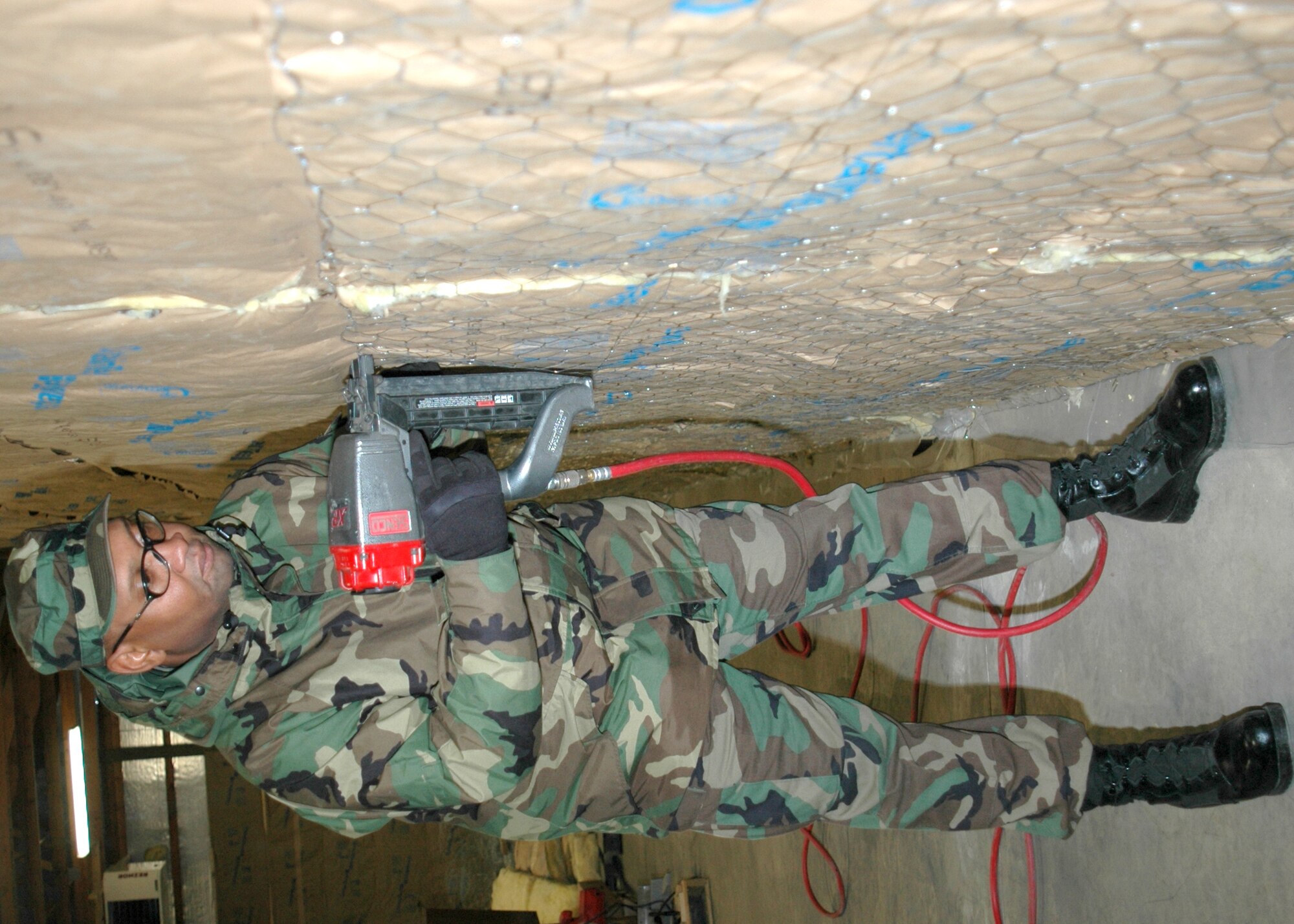 GRISSOM AIR RESERVE BASE, Ind., -- Tech. Sgt. James Robison, an engineering assistant craftsman with the 434th Civil Engineers Squadron, fastens chicken wire over newly placed insulation to help keep it in place during renovation of a pole barn on base. (U.S. Air Force photo/Senior Airman Ben Mota)