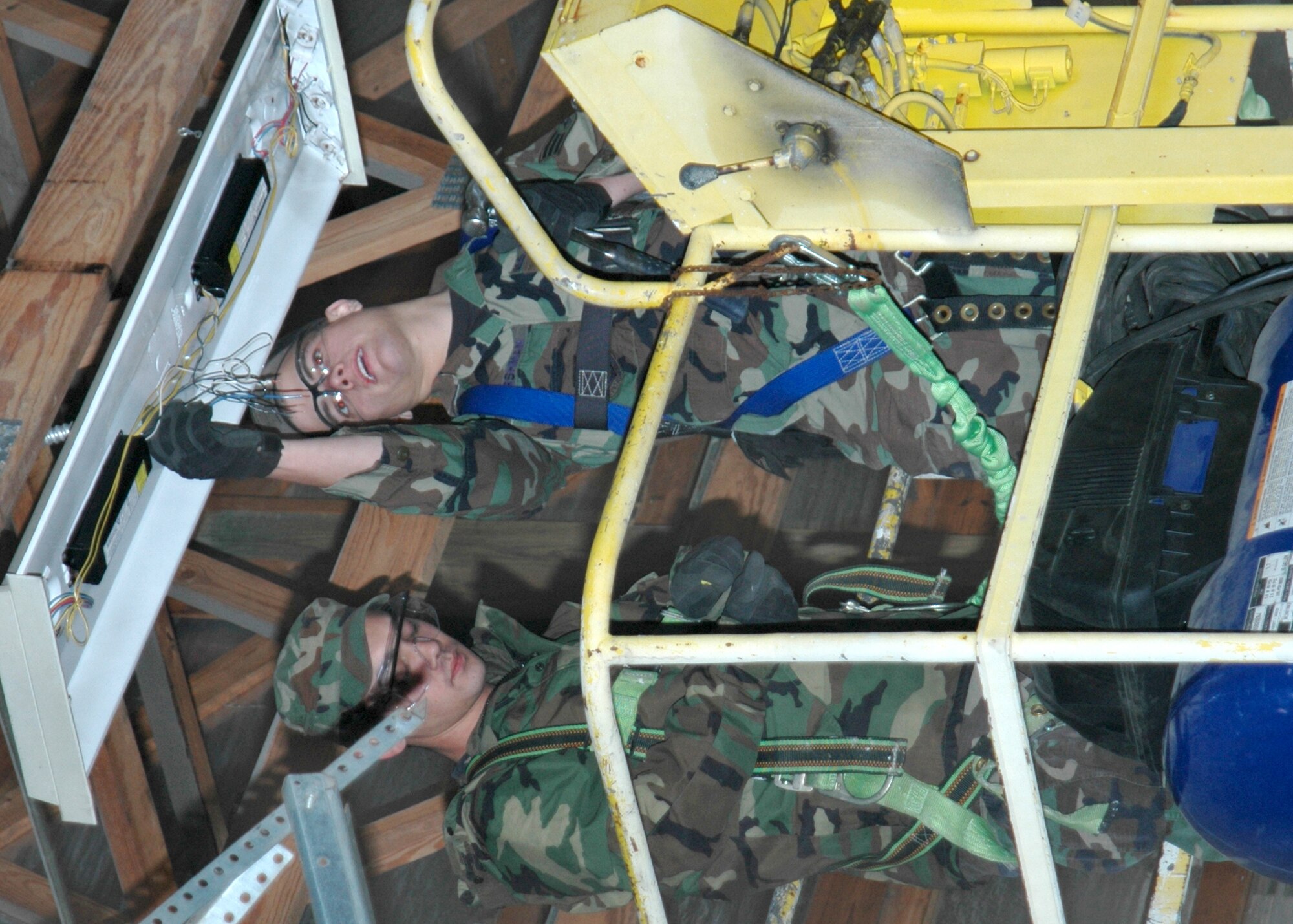 GRISSOM AIR RESERVE BASE, Ind., -- Senior Airman Dan Harshman, right, a utilities journeyman, and Senior Airman Phil Budnick, a  heavy equipment operator, remove a broken light fixture during renovation of a pole barn on base. (U.S. Air Force photo/Senior Airman Ben Mota)