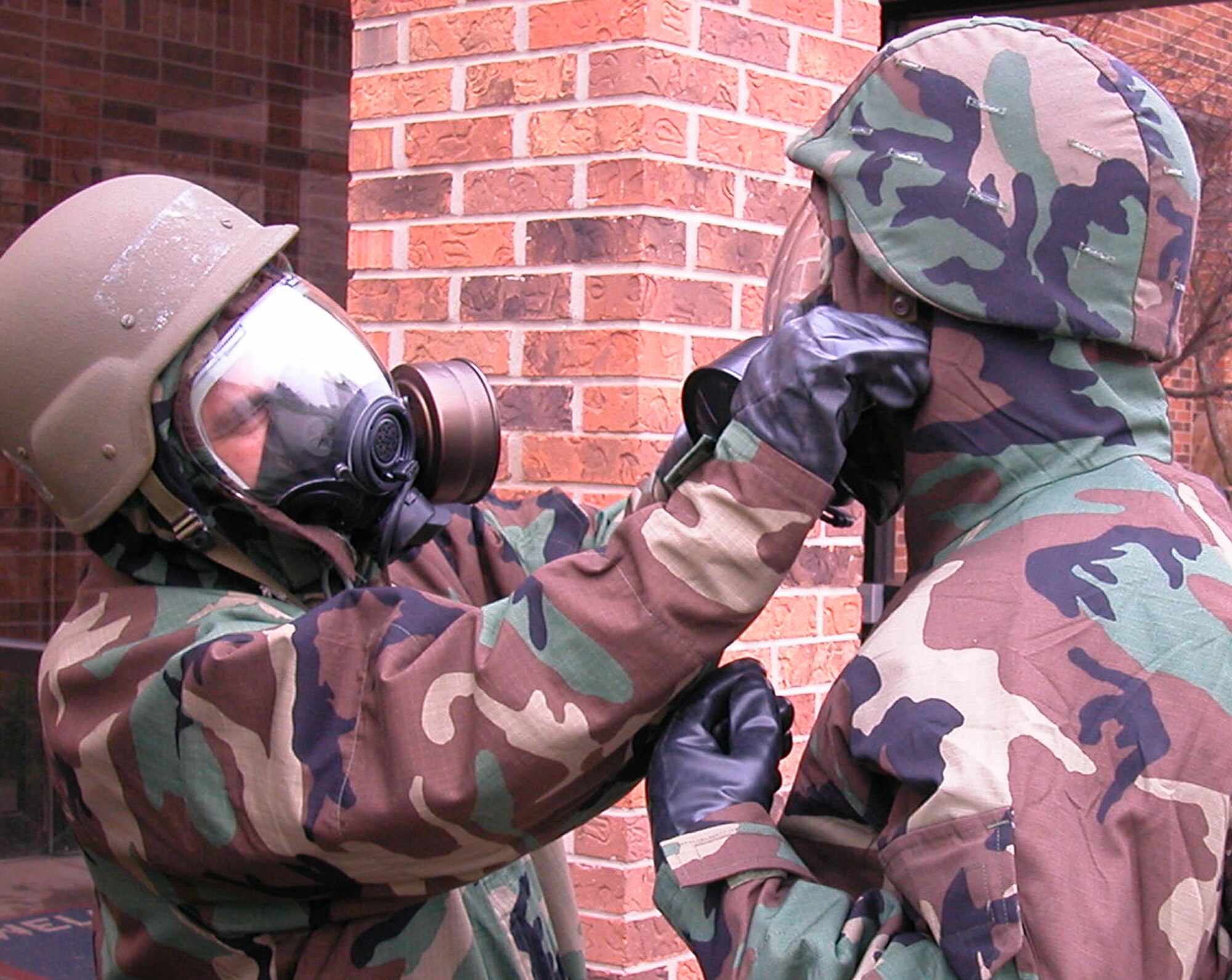 GRISSOM AIR RESERVE BASE, Ind., -- Senior Airman Omar Delacruz, left, helps Senior Airman Carl Berry with his JLIST suit as part of total quality training. Both Airmen are assigned to the 434th Air Refueling Wing public affairs office and were training to operate and perform taskings while wearing the protective gear. (U.S. Air Force photo/Senior Airman Chris Bolen)
