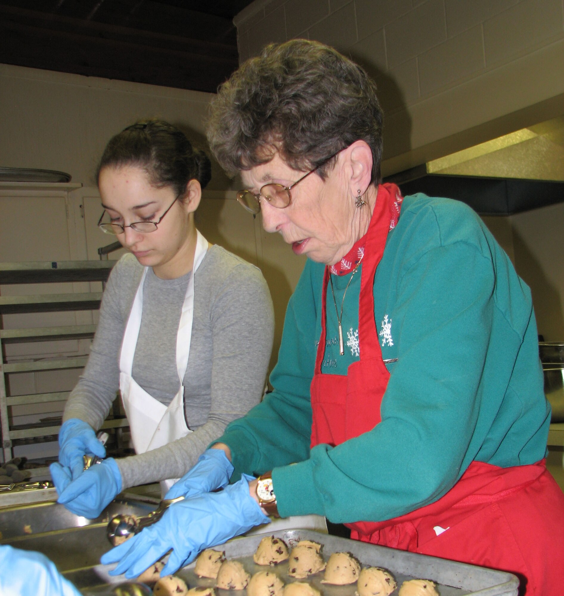 Airman 1st Class Arminda Gray, 341st Logistics Readiness Squadron, and Donna Burdette prepare chocolate chip cookies at the VFW Post 1087 Nov. 27. The cookies were sent in roughly 400 care packages to deployed servicemembers from Montana Dec. 1. (U.S. Air Force photo/Airman 1st Class Dillon White)
