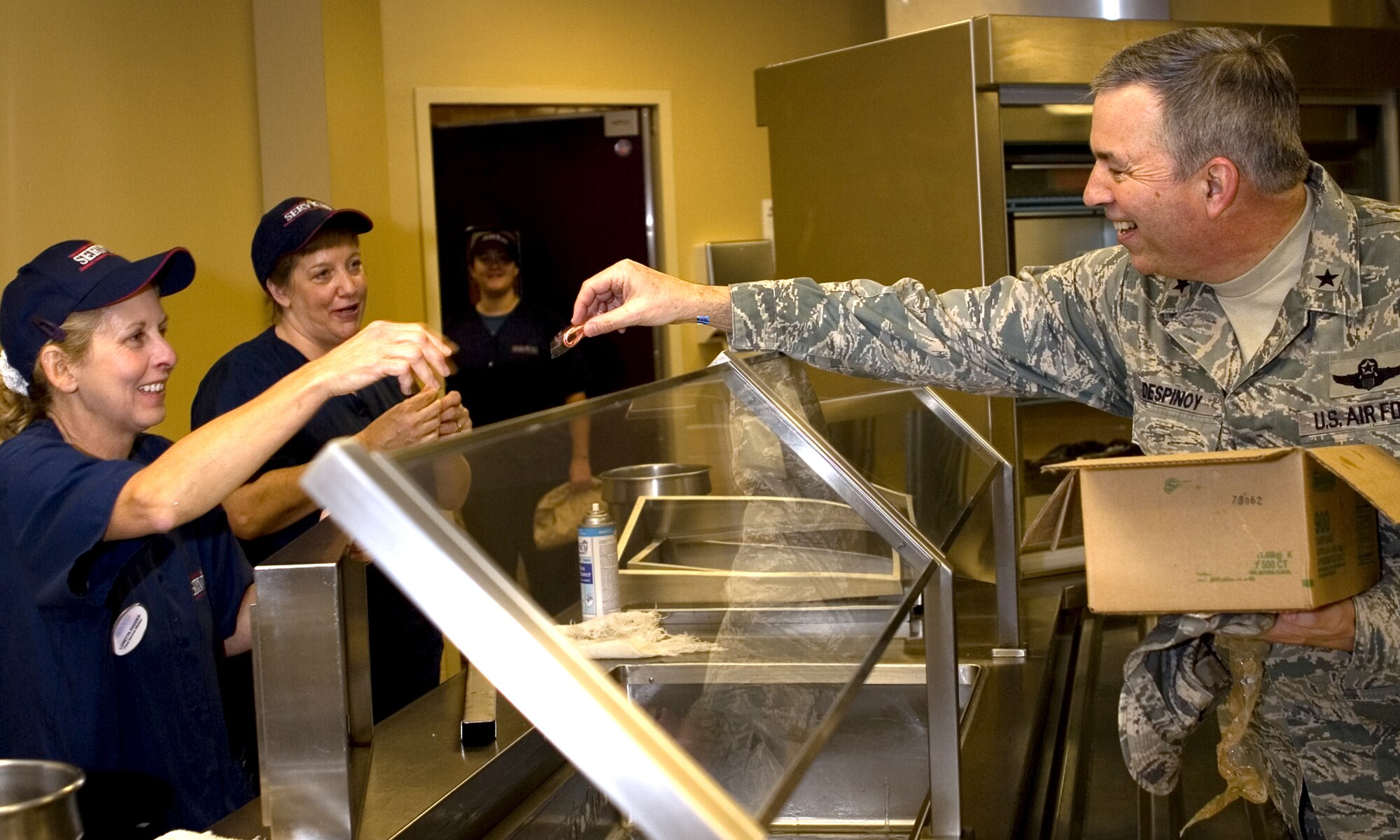 GRISSOM AIR RESERVE BASE, Ind., -- Brig Gen. Dean Despinoy, 434th Air Refueling Wing commander, passes out candy canes to workers at the dining facility. General Despinoy and other members of his staff visited various areas on base to pass out candy canes and wish personnel a joyous holiday season. (U.S. Air Force photo/Senior Airman Omar Delacruz)