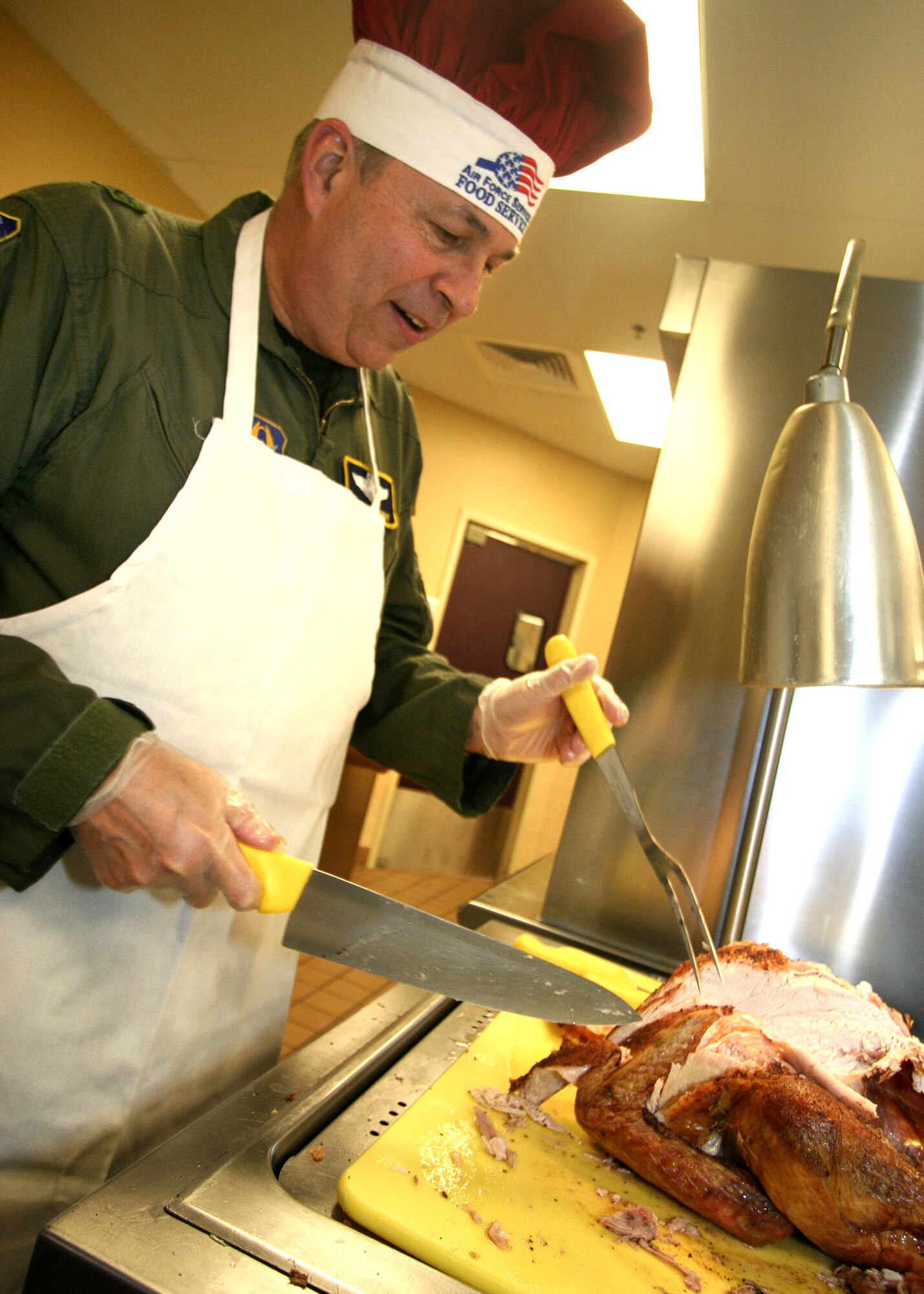 GRISSOM AIR RESERVE BASE, Ind., -- Brig Gen. Dean Despinoy, 434th Air Refueling Wing commander, carves up a turkey to serve to Airmen during the December unit training assembly. It is an annual tradition for commanders and senior leadership at Grissom to serve the Holiday meal to other unit members. (U.S. Air Force photo/Tech. Sgt. Patrick Kuminecz)