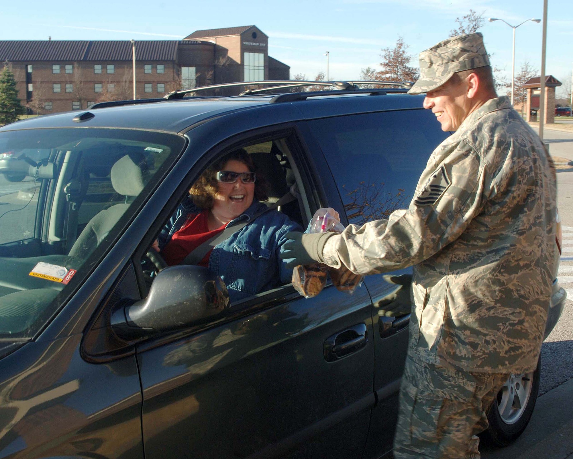 D.D. Breckle, wife of Staff Sgt. Thomas Breckle, 509th Civil Engineer Squadron, drives up to Mission’s End Club to drop off home baked cookies during the cookie drive Dec. 4. The donated cookies will be packaged and delivered to the Airman during the holiday season. (U.S. Air Force photo/Staff Sgt. Felicia R. Haecker) 
