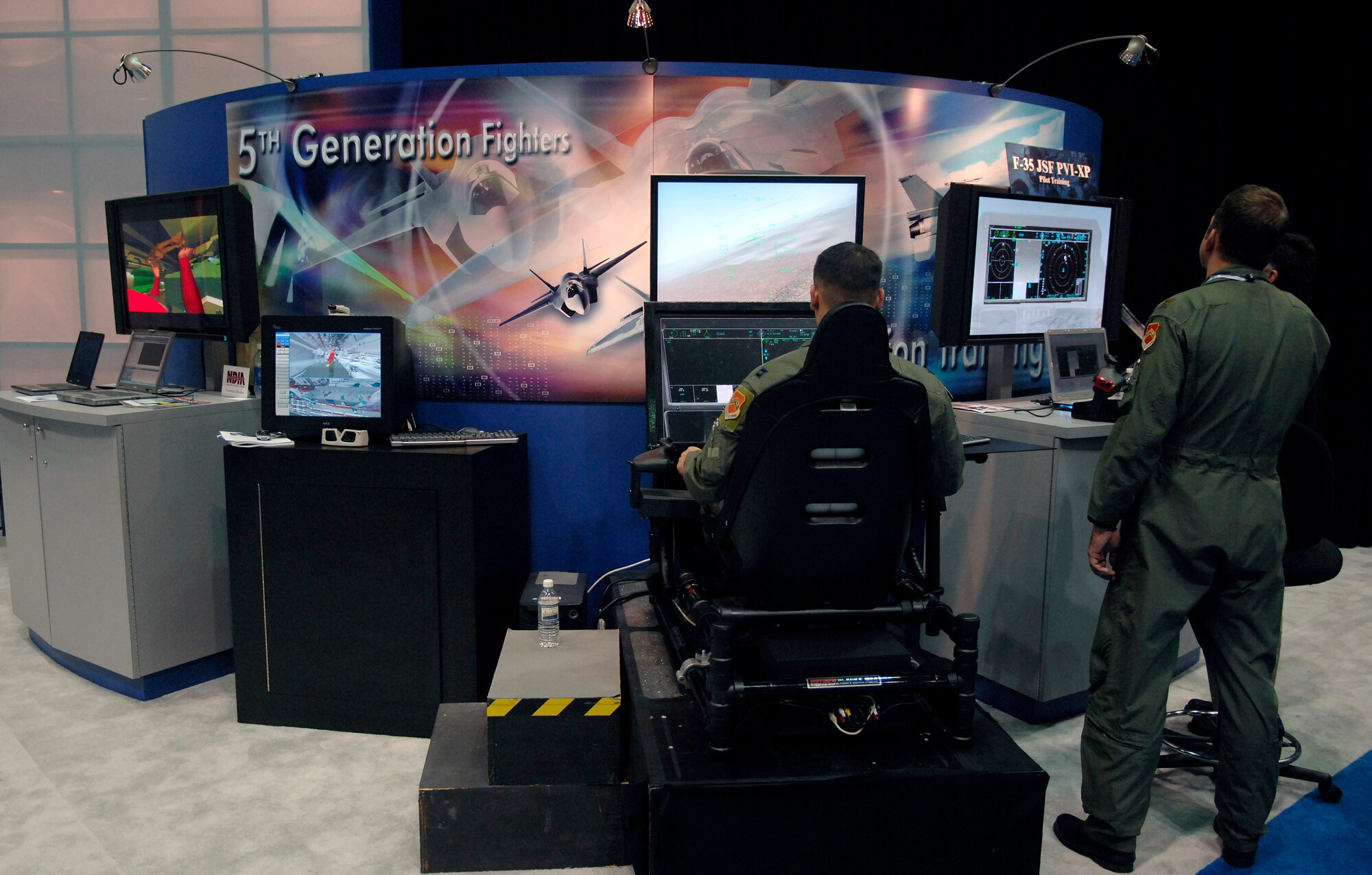 Capt. Matt Poisson (left) tries out some of the newest technology on an F-35 Joint Strike Fighter simulator while Maj. Jeff Simons studies his fellow pilot's actions Nov. 30 during the Interservice/Industry Training, Simulation and Education Conference in Orlando, Fla. Major Simons and Captain Poisson are F-16 Fighting Falcon pilots from Luke Air Force Base, Ariz. (U.S. Air Force photo/Tech. Sgt. Larry A. Simmons) 