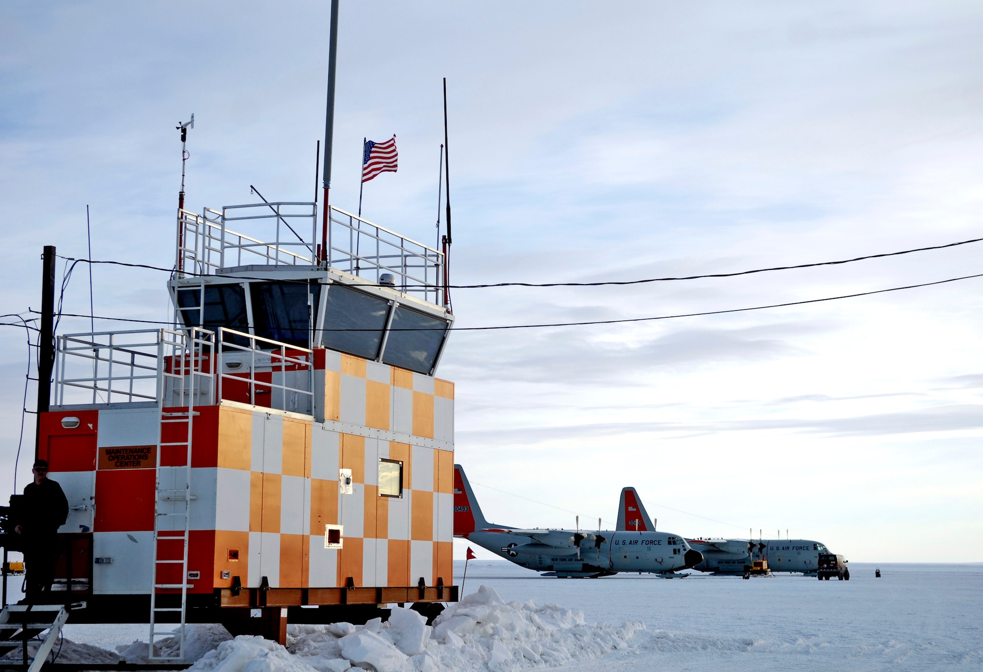 Two LC-130 Hercules sit in front of a control tower on the ice runway near McMurdo Station, Antarctica, Nov. 27 in preperation for use in Operation Deep Freeze. Active duty, Guard and Reserve Airmen from McChord Air Force Base, Wash., and the New York Air National Guard's 109th Airlift Wing, combined efforts to support the 13th Air Force-led Joint Task Force Support Forces Antarctica operation. (U.S. Air Force photo/Tech. Sgt. Shane A. Cuomo) 
