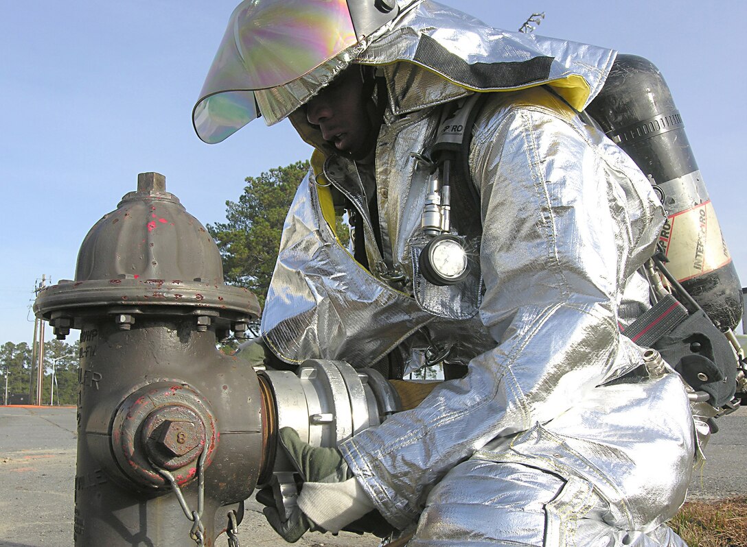 SEYMOUR JOHNSON AIR FORCE BASE, N.C.--Airman 1st Class Dweyne Krauser, a firefighter with the 916th Civil Engineer Squadron here, configures the firehose water supply during a structural drill December 1st. The structural drill simulated firefighter response to a burning building with victims inside. The drill was part of an evaluation during the 916th Air Refueling Wing's recent Staff Assistance Visit.