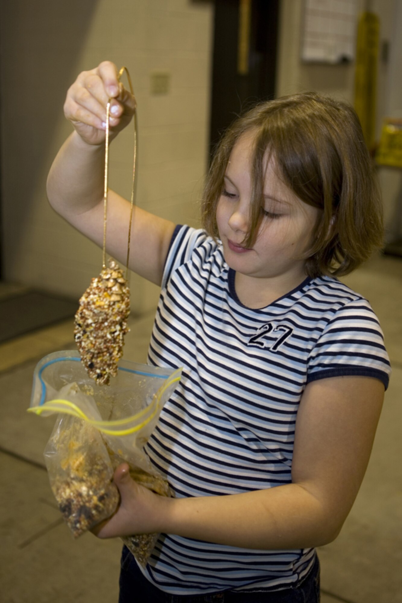 GRISSOM AIR RESERVE BASE, Ind. -- Nine-year-old Samantha Durr adds the finishing touches to her bird feeder during Santa's recent visit to Grissom. The Airmen Family Readiness Center and the Grissom Fire Department also sponsored other activities for children including personalizing gift bags and Christmas stocking, a gift program, and a free raffle. The event, held at the fire department, was a family affair. (U.S. Air Force photo/Senior Airman Omar Delacruz)