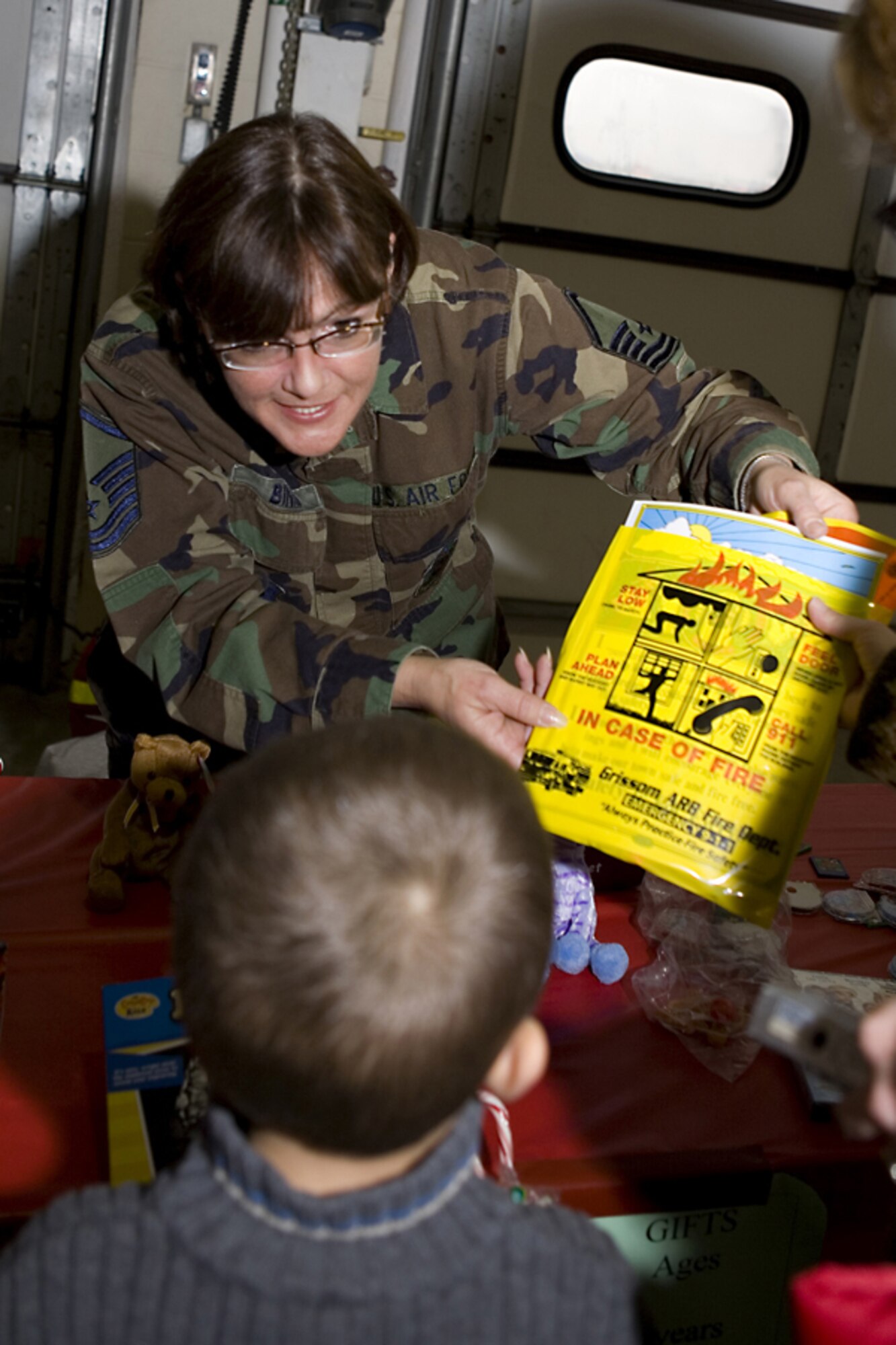 GRISSOM AIR RESERVE BASE, Ind. -- Master Sgt. Melissa Binns, a family support technician with the Airmen Family Readiness Center, shows Abram Shepherd one of the toys he  received as part of Santa's surprise visit to Grissom ARB. Santa's visit was made possible by the joint efforts of the Airmen Family Readiness Center and the Grissom Fire Department. (U.S. Air Force photo/Senior Airman Omar Delacruz)