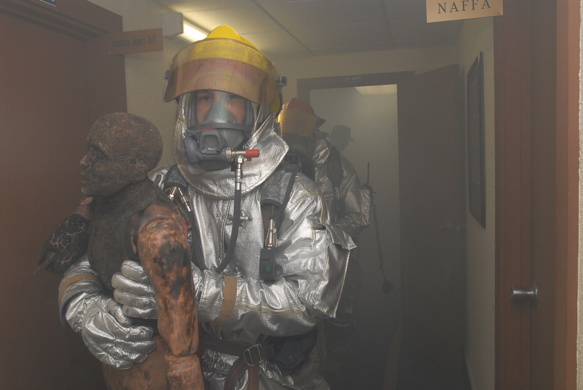 A base firefighter rescues an injuried "person" while other firefighters put out a simulated fire during a Local Operational Readiness Exercise Beverly High 08-02 scenario at Kadena Air Base, Japan, Dec. 4, 2007. This scenario tested the firefighters ability to respond to a fire while working with other agencies. (U.S. Air Force /Senior Airman Darnell T. Cannady)