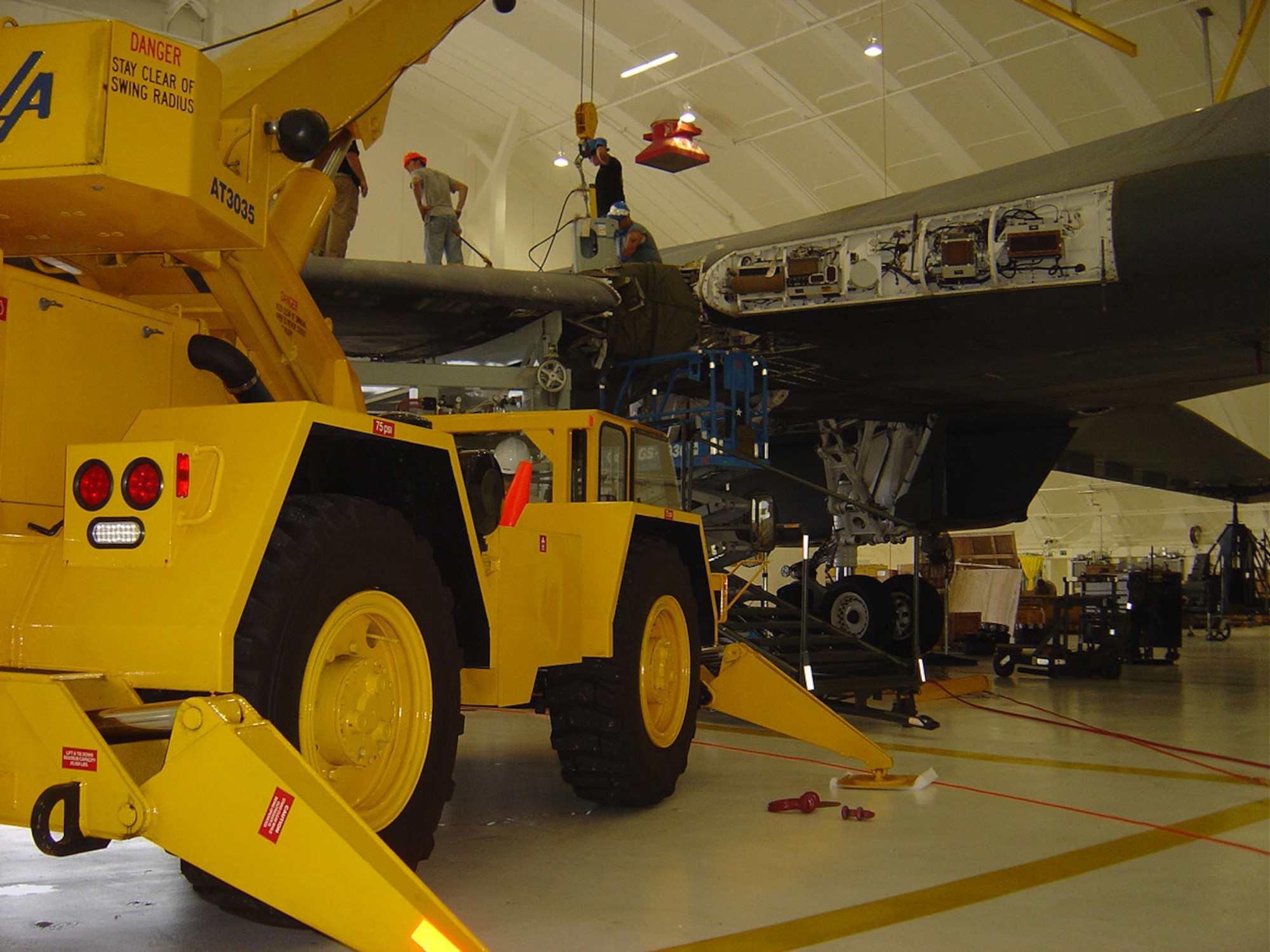 Maintenance crew from Tinker AFB, Okla., and the 36th Maintenance Squadron remove the wing pivot pin during repair efforts of the B-1B Lancer that caught fire on Andersen September 2005. The aircraft is scheduled to return to full mission capability status in summer of 2008. (Courtesy photo)