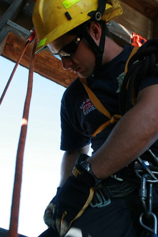 Robert Rezende, a member of the San Diego Fire Department, prepares his safety harness before rappelling here Dec. 4. The class helped the students prepare to perform rescue missions after a catastrophic earthquake. (U.S. Marine Corps photo by Lance Cpl. Austin Goacher) (Released)