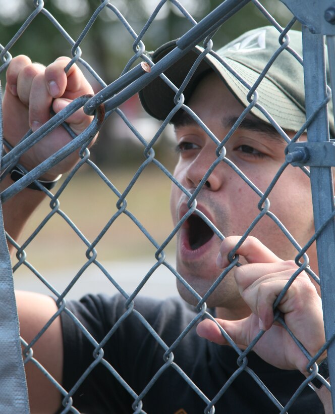 A simulated demonstrator yells through the the fence at Marines in a simulated embassy. The Marines provided a mock embassy with security reinforcements during the 24th MEU's COMPTUEX here Dec. 10.