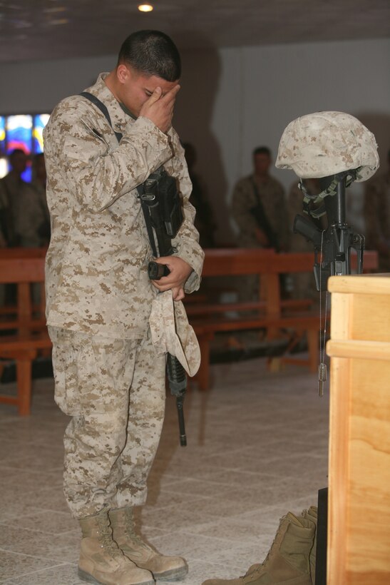 A Marine with Marine Wing Security Battalion 372, pays his respect for Cpl. Allen C. Roberts, during a memorial service at the Al Asad Chapel, Dec. 5. Roberts died Nov. 28, while conducting a mounted combat patrol in defense of Al Asad, Iraq.