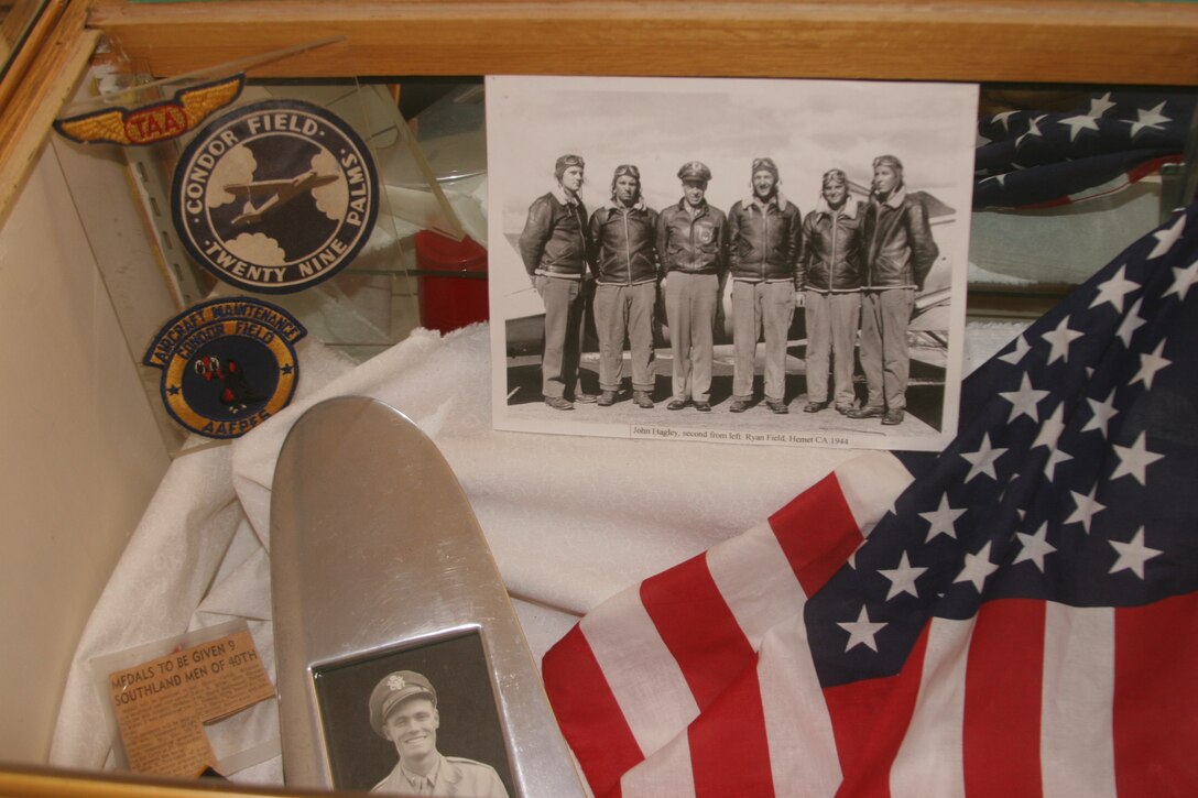 Set in a display case at the Old Schoolhouse Museum, old pictures, flags, newspaper clippings and military badges help portray Twentynine Palms, Calif., during World War II.