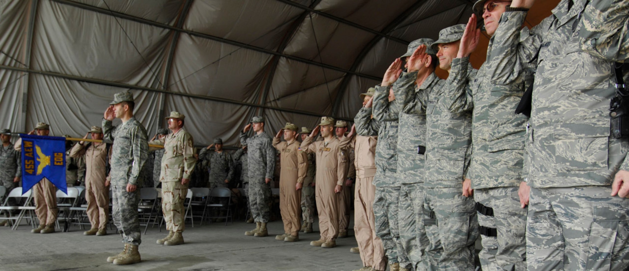 BAGRAM AIR BASE, Afghanistan - Members of the 455th Expeditionary Operations Group salute during the singing of the National Anthem during the group's change of command ceremony here, Dec. 5, 2007.  Command of the group changed hands from Col. Eric Nelson to Col. Arthur McGettrick.  (U.S. Air Force Photo by Staff Sgt. Joshua Jasper)
