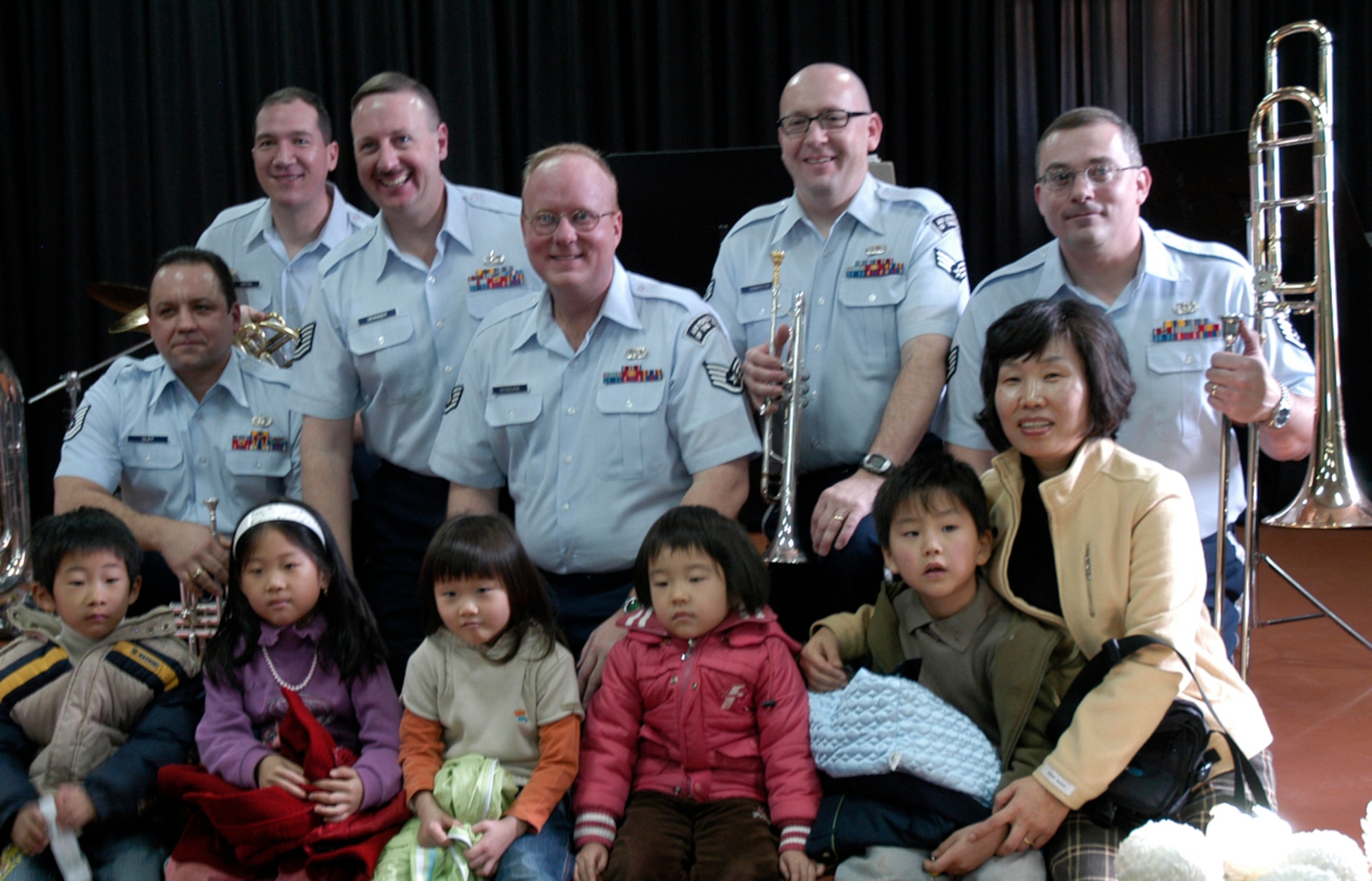 KUNSAN AIR BASE, South Korea -- A teacher and her students of Na Po Elementary School have a photo take with the Air Force Band of the Pacific after their performance at the local Gunsan City School Dec. 5. The Elmendorf Air Force Base, Alaska based band performed for more than 300 students, parents and teachers as part of their civic outreach and the base?s Good Neighbor Program. (U.S. Air Force Photo/Master Sgt. Sean P. Houlihan)