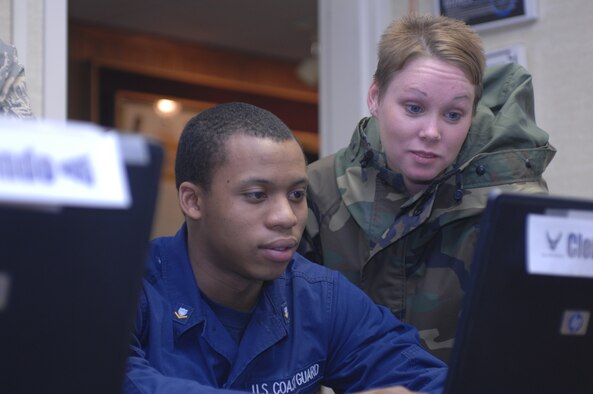 Coast Guard Petty Officer 3rd Class Perry Clement and Senior Airman Emily Burgess, Airman Leadership School students, look over some of the curriculum at the Elmendorf Professional Military Education center Nov. 29. Petty Officer Clement is a machinery technician for District 17. (U.S. Air Force photo by Airman 1st Class David Carbajal)