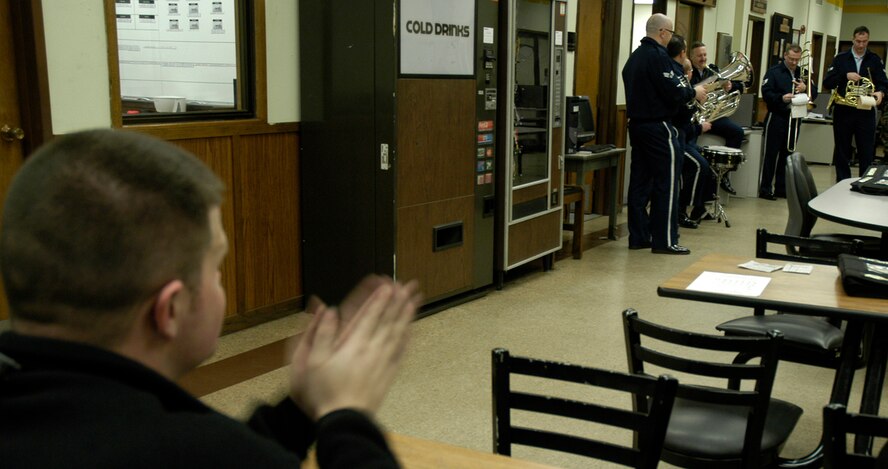 KUNSAN AIR BASE, South Korea -- Staff Sgt. Jeremy Ruff, 80th Aircraft Maintenance Unit applauds for the Air Force Band of the Pacific during a holiday tour performance tour stop to his work center here Dec. 4. The Elmendorf Air Force Base, Alaska based band is here for a week spreading holiday cheer across the base and in the local Gunsan City area. (U.S. Air Force Photo/Master Sgt. Sean P. Houlihan)                               