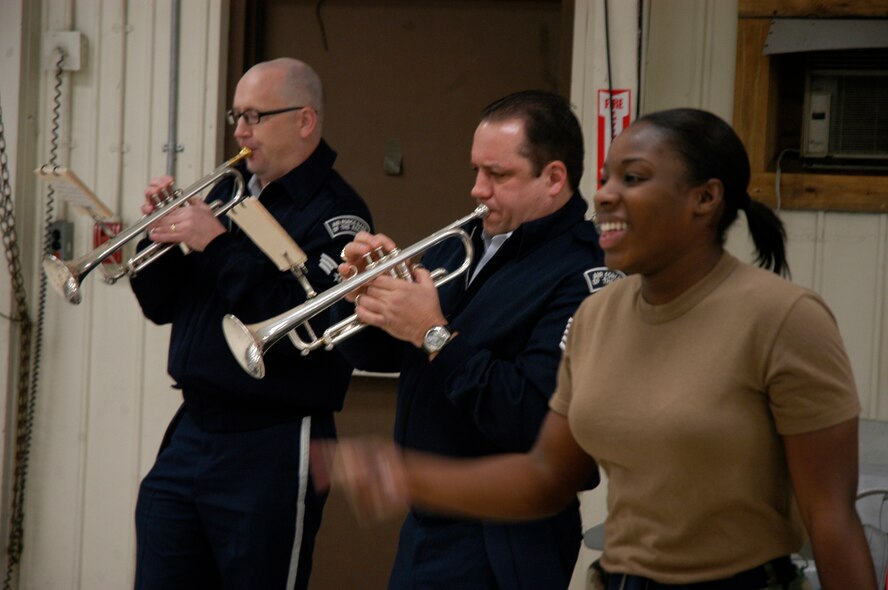 KUNSAN AIR BASE, South Korea -- Staff Sgt. Sabria Smith-Vann, 8th Maintenance Squadron sings along with the Air Force Band of the Pacific during a holiday tour performance tour stop to her work center here Dec. 4. The Elmendorf Air Force Base, Alaska based band is here for a week spreading holiday cheer across the base and in the local Gunsan City area. (U.S. Air Force Photo/Master Sgt. Sean P. Houlihan)                        