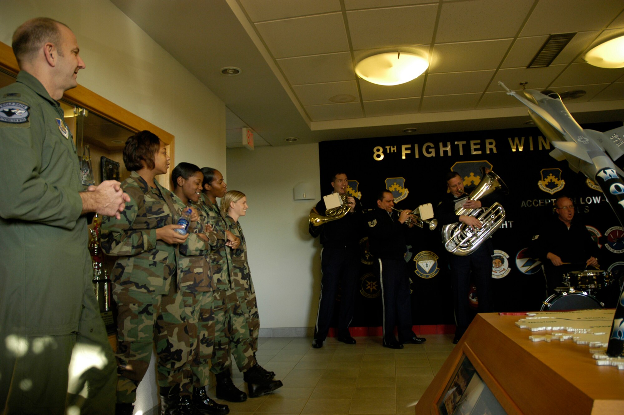 KUNSAN AIR BASE, South Korea -- Colonel Creig Rice, 8th Fighter Wing Vice Commander listens to the Air Force Band of the Pacific perform a Christmas carol along with other 8th Fighter Wing Airmen during the band's holiday tour here Dec. 3. The Elmendorf Air Force Base, Alaska based band is here for a week spreading holiday cheer across the base and in the local Gunsan City area. (U.S. Air Force Photo/Master Sgt. Sean P. Houlihan)