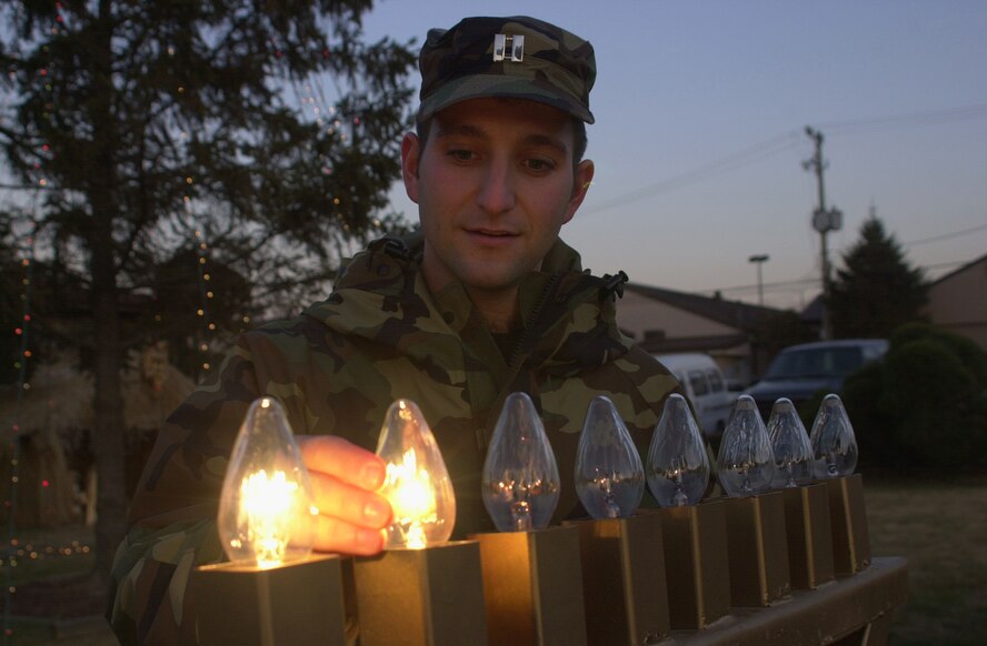 OSAN AIR BASE, Republic of Korea --  Chaplain (Capt.) Michael Newton, with the 51st Fighter Wing, lights the second lamp of the menorah during a ceremony at the base chapel here Dec. 5. Lighting the menorah is part of the Hanukkah holiday ceremony, which takes place this year from Dec. 4 to 12. One lamp will be lit each of the eight nights of the holiday. (U.S. Air Force photo by Staff Sgt. Benjamin Rojek)
