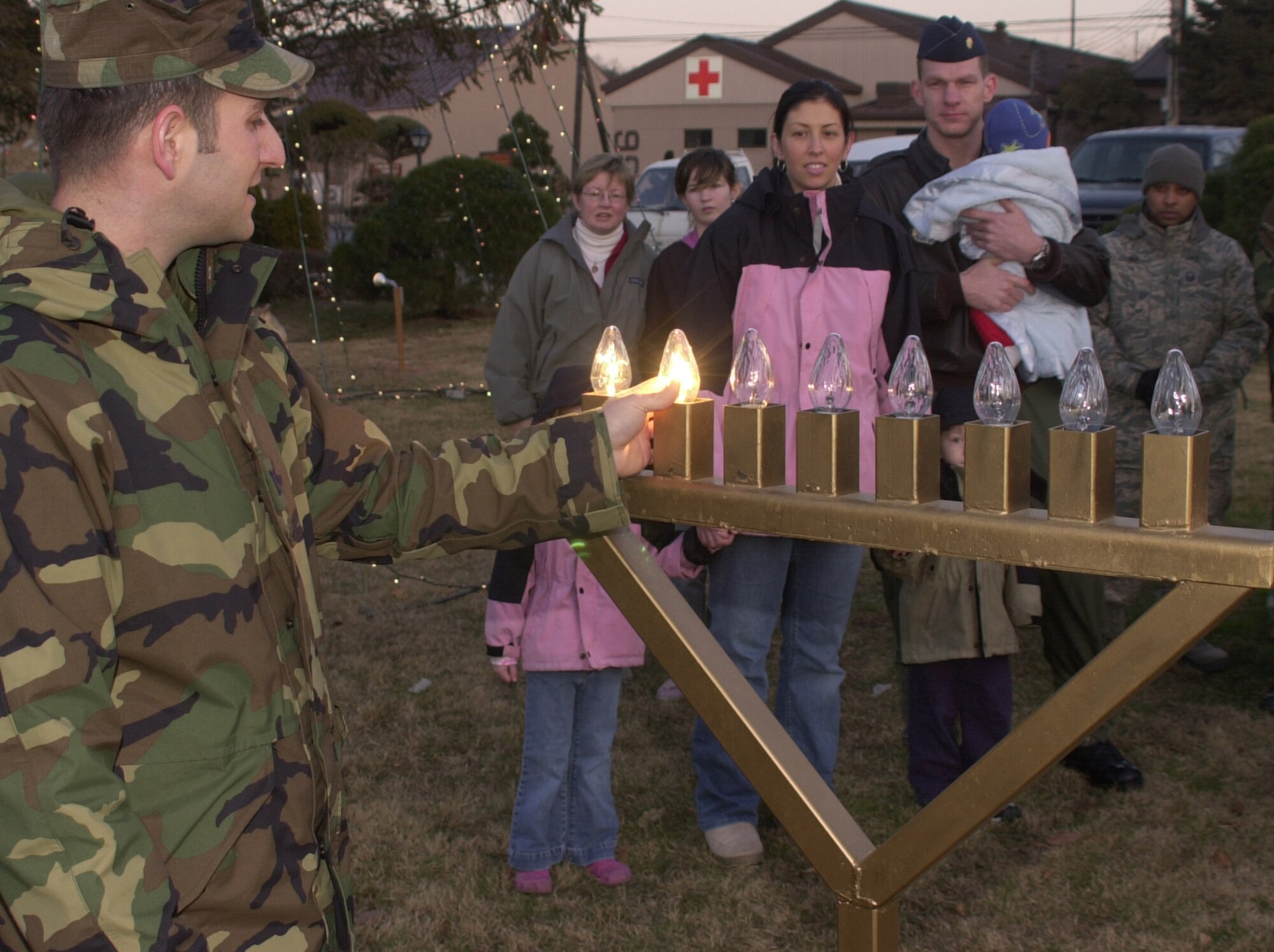 OSAN AIR BASE, Republic of Korea --  Chaplain (Capt.) Michael Newton, with the 51st Fighter Wing, lights the second lamp of the menorah during a ceremony at the base chapel here Dec. 5. Lighting the menorah is part of the eight-day Hanukkah holiday celebration. One lamp is lit each day of Hanukkah. (U.S. Air Force photo by Staff Sgt. Benjamin Rojek)