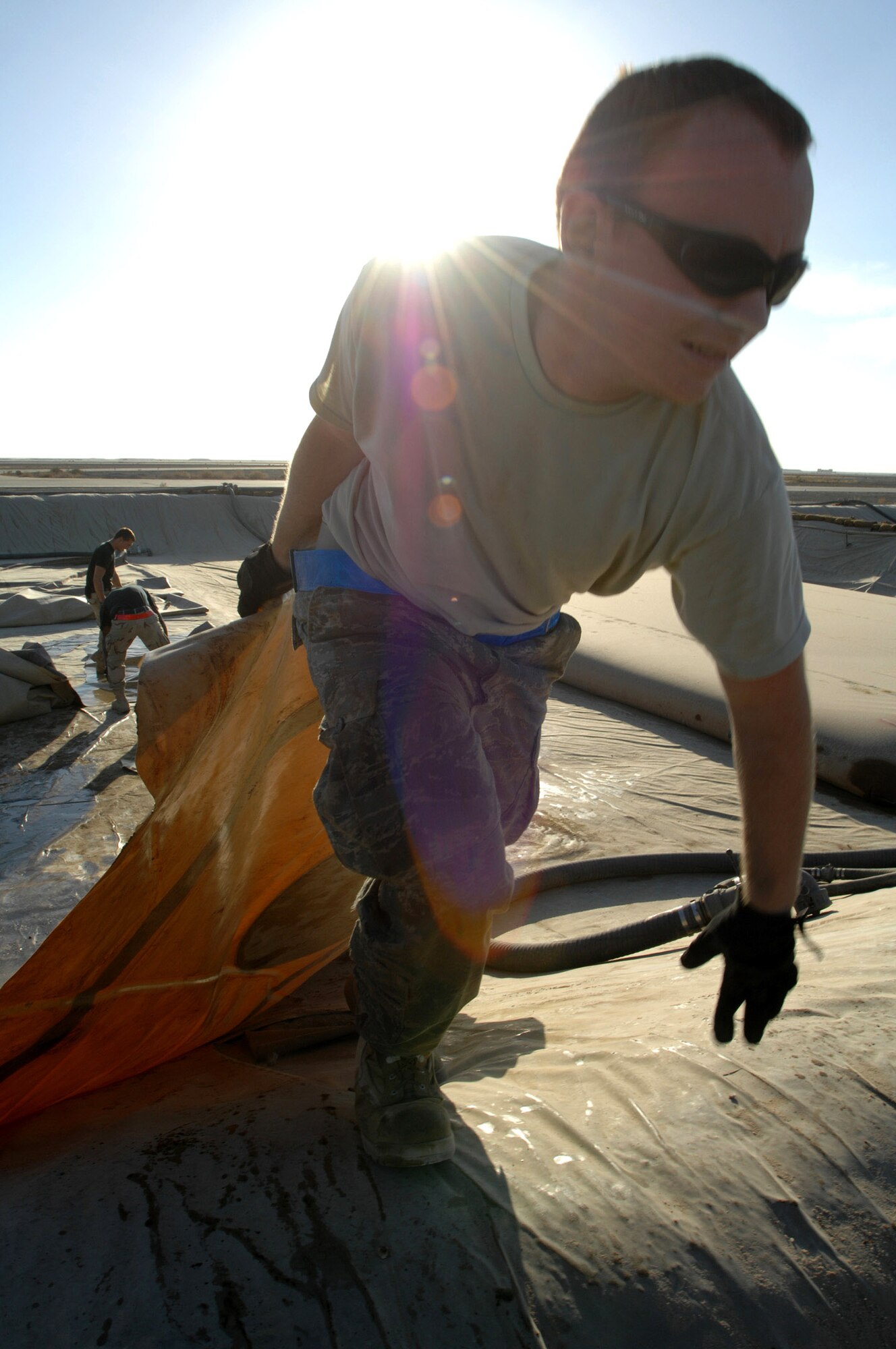 Senior Airman Jay Pickle helps install a 900-pound fuel bladder Dec. 3 at Ali Base, Iraq. Airmen from the 407th Expeditionary Logistics Readiness Squadron fuels shop periodically replace fuel bladders to prevent ruptures.  The new bladder can hold up to 50,000 gallons of fuel.  Airman Pickle is deployed from Yokota Air Base, Japan. (U.S. Air Force photo/Airman 1st Class Jonathan Snyder) 