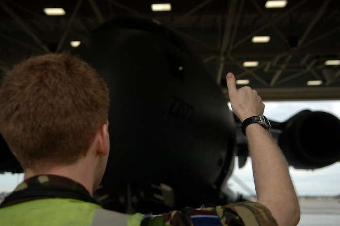 An Airman from the Royal Air Force gives the ?Thumbs Up? to Royal Air Force Airmen in the cockpit of a British Royal Air Force C-17 as it is towed out of Nose Dock 1 Monday on the Charleston AFB flightline. Royal Air Force Airmen arrived Sunday to conduct an engine replacement and to obtain additional training from our Team Charleston Airmen. The Royal Air Force currently has five C-17s in their inventory (U.S. Air Force photo/Senior Airman Nicholas Pilch)