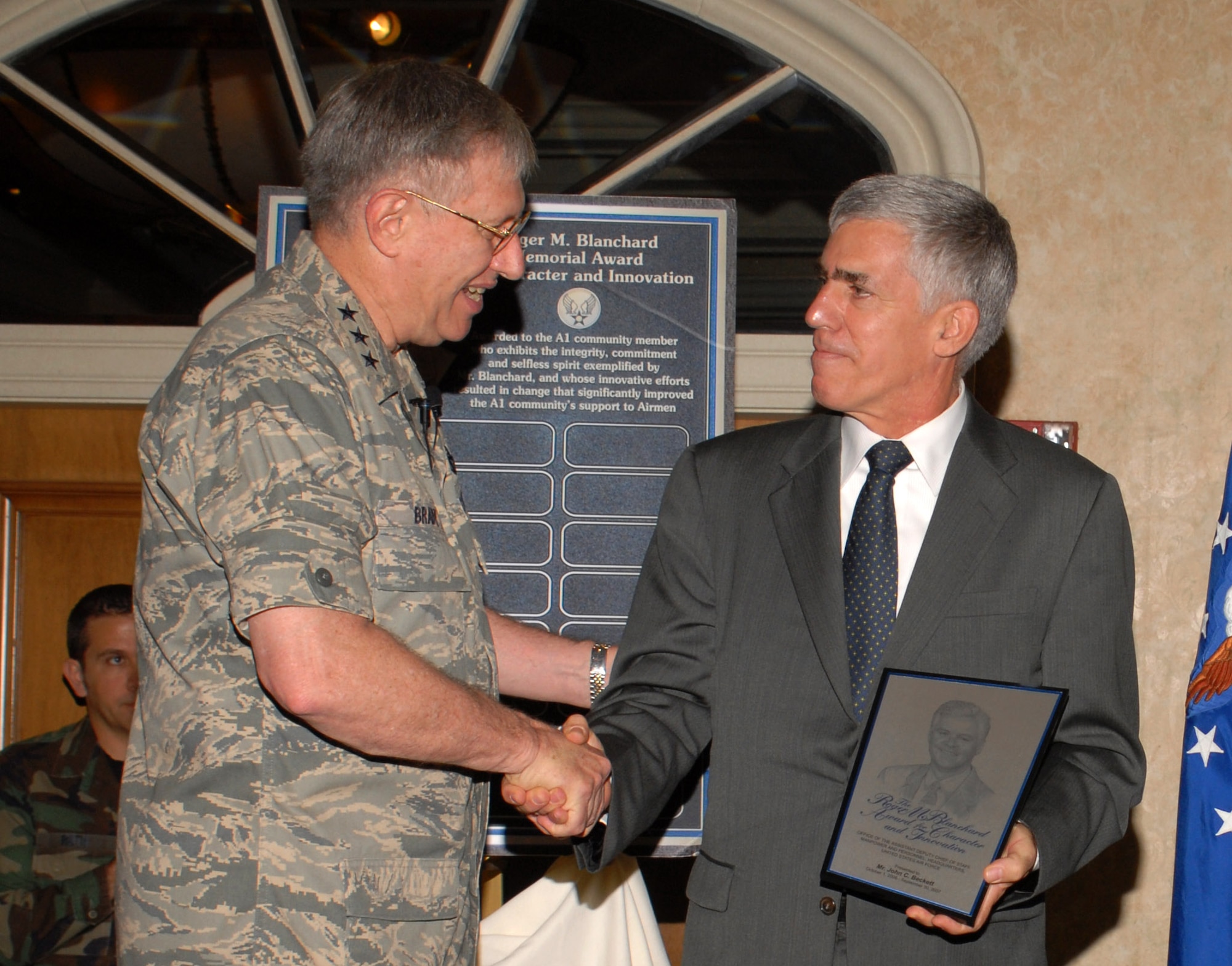 Lt. Gen. Roger A. Brady presents the first Roger M. Blanchard Memorial Award for Character and Innovation to John Beckett at the 2007 Worldwide Manpower and Personnel Training and Professional Development Conference Nov. 30 in San Antonio. General Brady is the Air Force deputy chief of staff for personnel. Mr. Beckett serves as the Air Force's Survivor Assistance Program manager at the Pentagon. The new award honors the former assistant deputy chief of staff for manpower and personnel, who passed away Sept. 30. (U.S. Air Force photo/Javier Garcia)