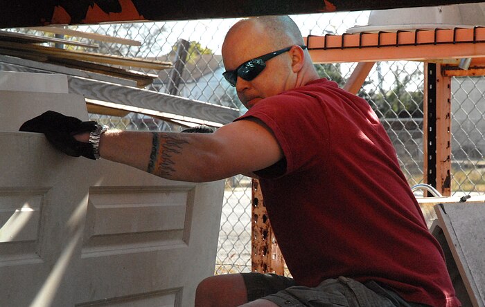 Staff Sgt. Michael Sibley, 437th Aerial Port Squadron, moves doors in the Habitat for Humanity outdoor storage area in downtown Charleston Saturday. (U.S. Air Force photo/Tech. Sgt. Paul Kilgallon)   