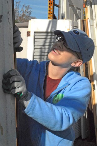 Airman 1st Class Angela Galewood, 437th Logistics Readiness Squadron, inspects a door to make sure it is serviceable Saturday at the Habitat for Humanity outdoor storage area in downtown Charleston. (U.S. Air Force photo/Tech. Sgt. Paul Kilgallon)   