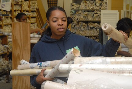 Tech. Sgt. Nina Murphy, 437th Mission Support Squadron, sorts donated wallpaper Saturday at the Habitat for Humanity donation center in downtown Charleston. The First Six sponsors many programs and initiatives advancing the cause of enlisted people and their families as well as the local community. (U.S. Air Force photo/Tech. Sgt. Paul Kilgallon)