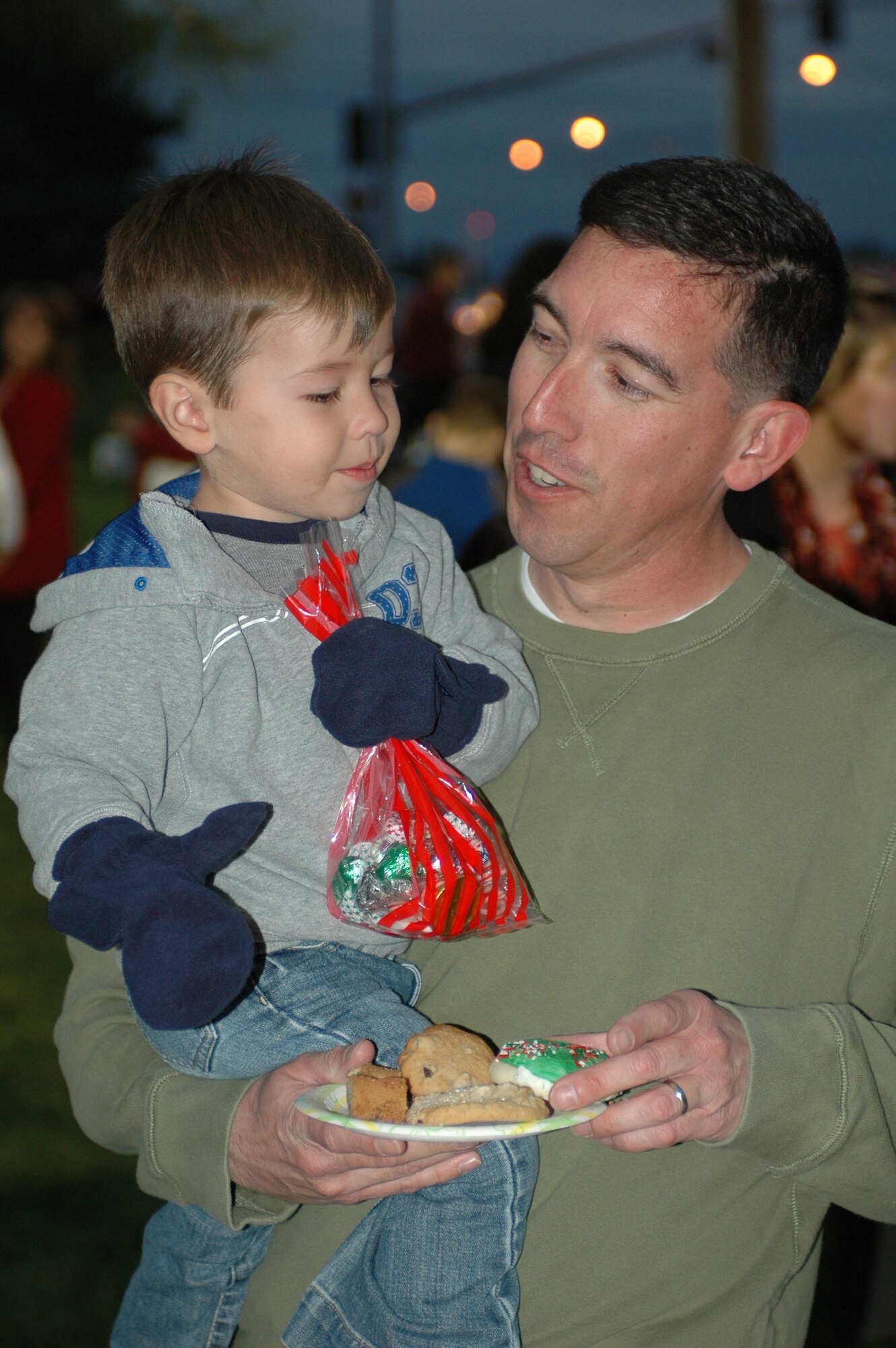 Master Sgt. Tim Miles, 60th Equipment Maintenance Squadron, and his son Jack, enjoy cookies provided to Team Travis members at this year’s Christmas tree and Menorah lighting ceremony Dec. 3. (U.S. Air Force photo/Senior Airman Shaun Emery)