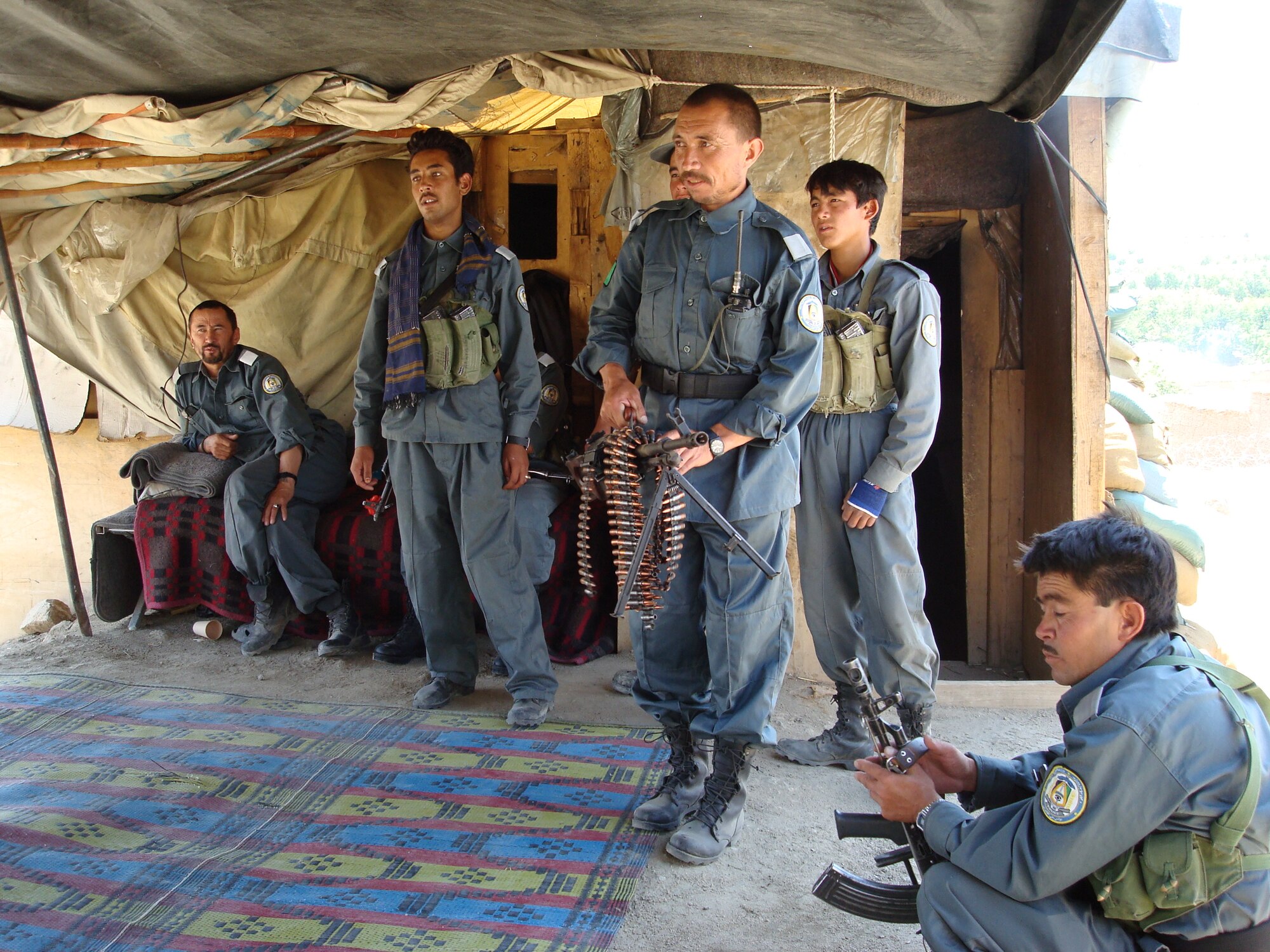 Members of the Afghan National Police here gather at a roadside checkpoint in July 2007.  A new reform effort is underway by the Combined Transition Command Afghanistan in Kabul to make the national police force more effective and less corrupt.  A five- to seven-year program known as Focused District Development, or FDD, is designed to transform the ANP into an independent, well-trained, ethnically-balanced, respectable and sustainable Afghan national security force.  (Air Force photo by Capt. Bob Everdeen)