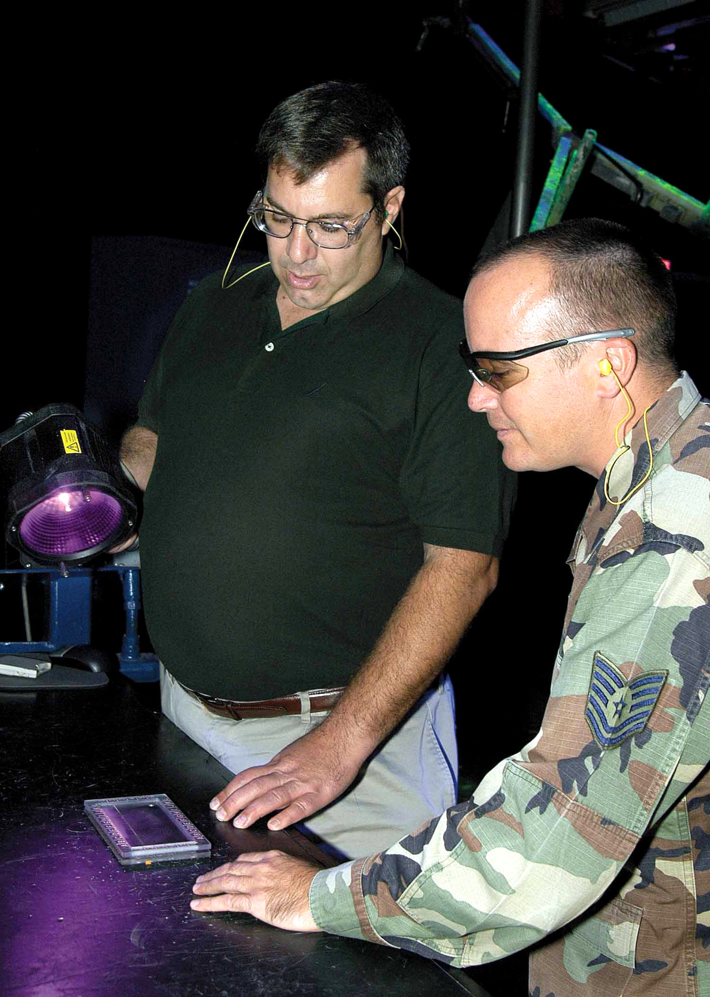 Michael Makowicz discusses local training administration with Tech. Sgt. Jim Loncher in November at Tinker Air Force Base, Okla. Technicians find fine cracks in aircraft engine components using a black light for help. Mr. Makowicz is a nondestructive inspection engineer, and Sergeant Loncher is an Air Force NDI field liaison. (U.S. Air Force photo/Margo Wright) 

