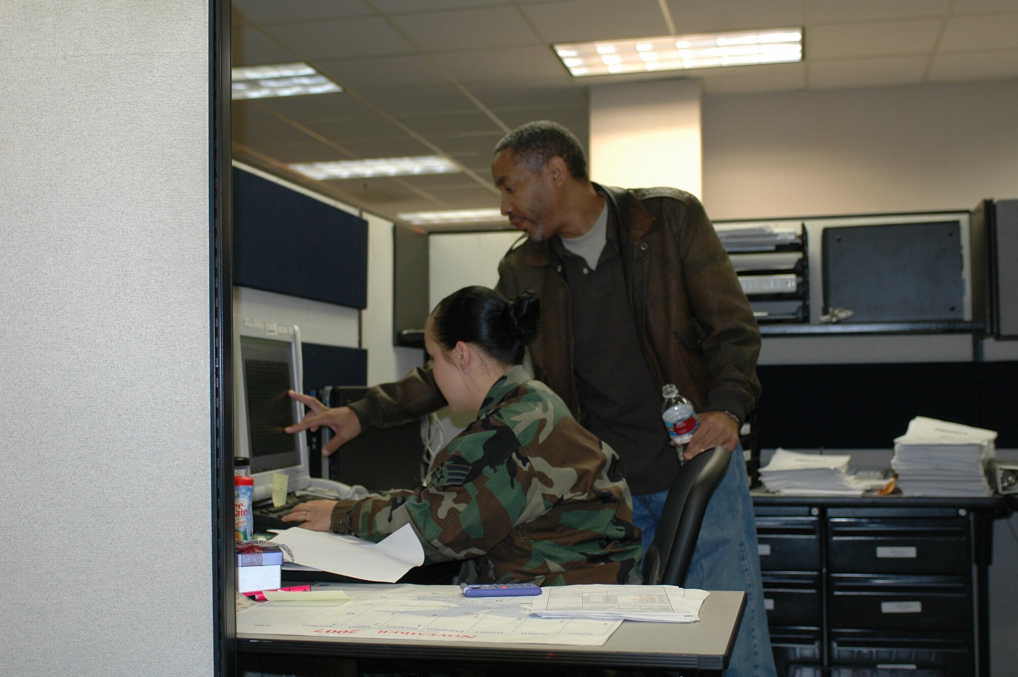 Darryl Thomas instructs Senior Airman Pamela Coats on an aspect of military pay processing. Civilians play a key role in the squadron’s ability to handle a heavy workload, as well as providing institutional knowledge about what has and has not worked in the past. (U.S Air Force photo/Nick DeCicco)