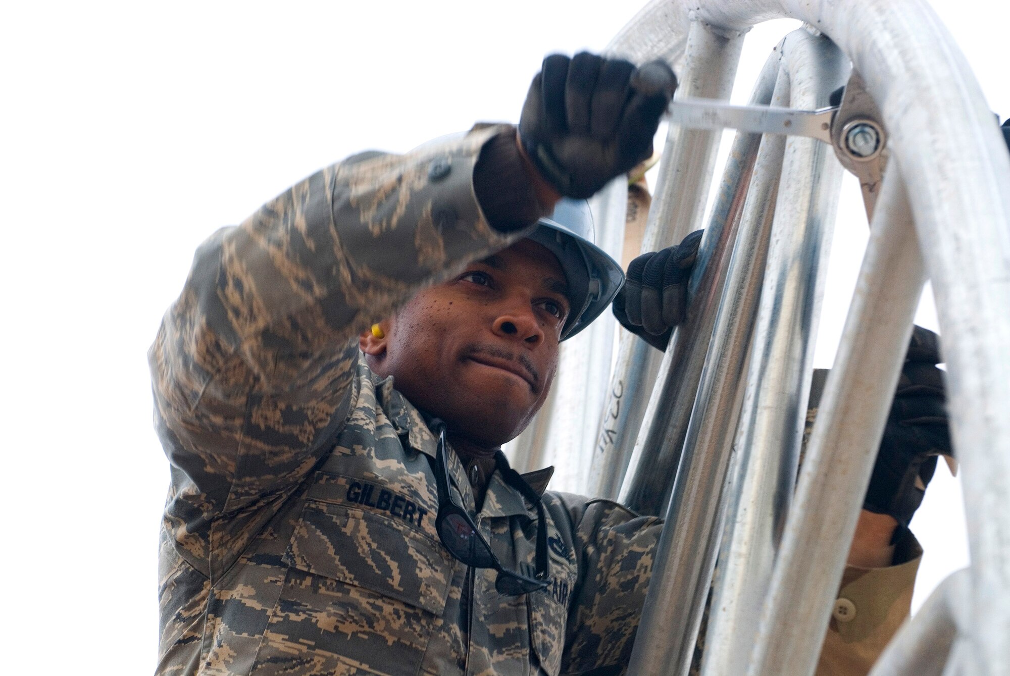 Staff Sgt. Andy Gilbert tightens a support beam to the frame of a temporary shelter Dec. 5 at Balad Air Base, Iraq. The new shelter will house vehicles for the 332nd Expeditionary Civil Engineer Squadron Explosive Ordnance Disposal Flight. Sergeant Gilbert, a 332nd ECES structural technician, is deployed from Yokota Air Base, Japan. (U.S. Air Force photo/Staff Sgt. Joshua Garcia) 
