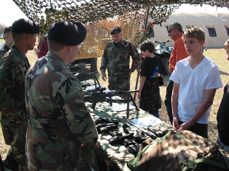 Members of the 919th Security Forces Squadron at Duke Field educate family members on weapon systems during the 919th Special Operations Wing's Family Day events Dec. 1. Squadrons from the wing had booths lined up throughout the Duke Field fair grounds to display what their missions are. (U.S. Air Force Photo/Master Sgt. Paul Morales)
