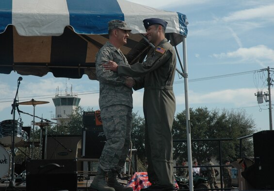 Brig. Gen. Michael Callan (left), Air Force Special Operations Forces commander, presents 1st Lt. Mario Rosa Gale, 711th Special Operations Squadron navigator, with a General's Coin during the 919th Special Operations Wing's Family Day held Dec. 1. General Callan coined members that went above and beyond the call of duty during a series of deployments earlier this year. (U.S. Air Force Photo/Jasmine DeNamur)