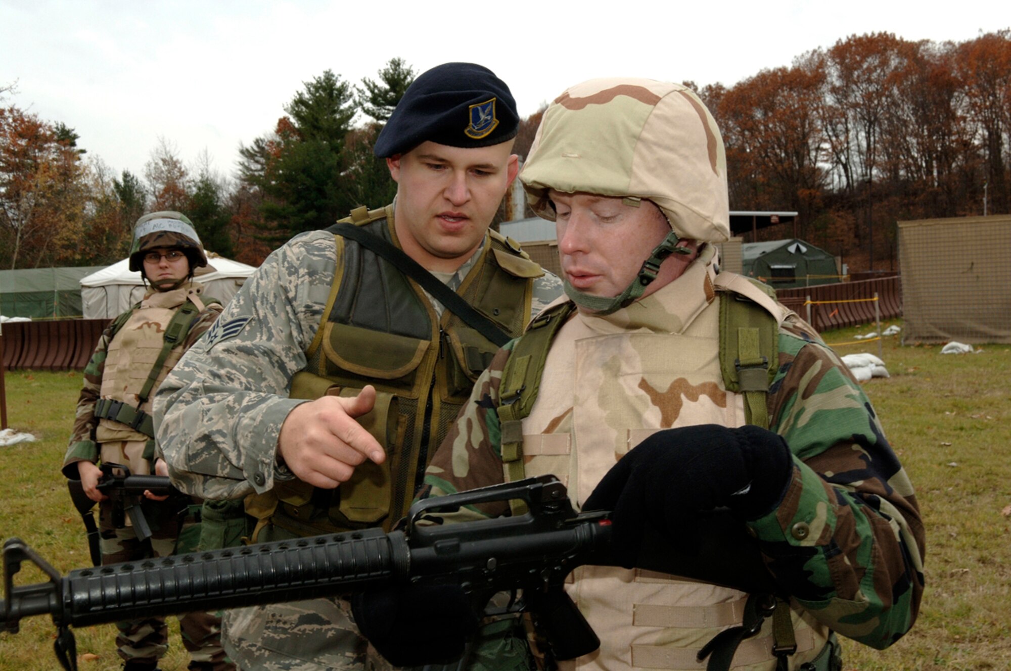 HANSCOM AFB, Mass. -- Senior Airman Matthew Medsger, 66th Security Forces Squadron (left), gives pointers on M16 rifle use and safety to Capt. Patrick Graham, 66th Contracting Squadron, during a weapons familiarization training session at Camp Patriot Nov. 29. Expeditionary Airman Combat Skills training prepares Airmen of all career fields for deployments in the Area of Responsibility. (U.S. Air Force photo by Jan Abate)