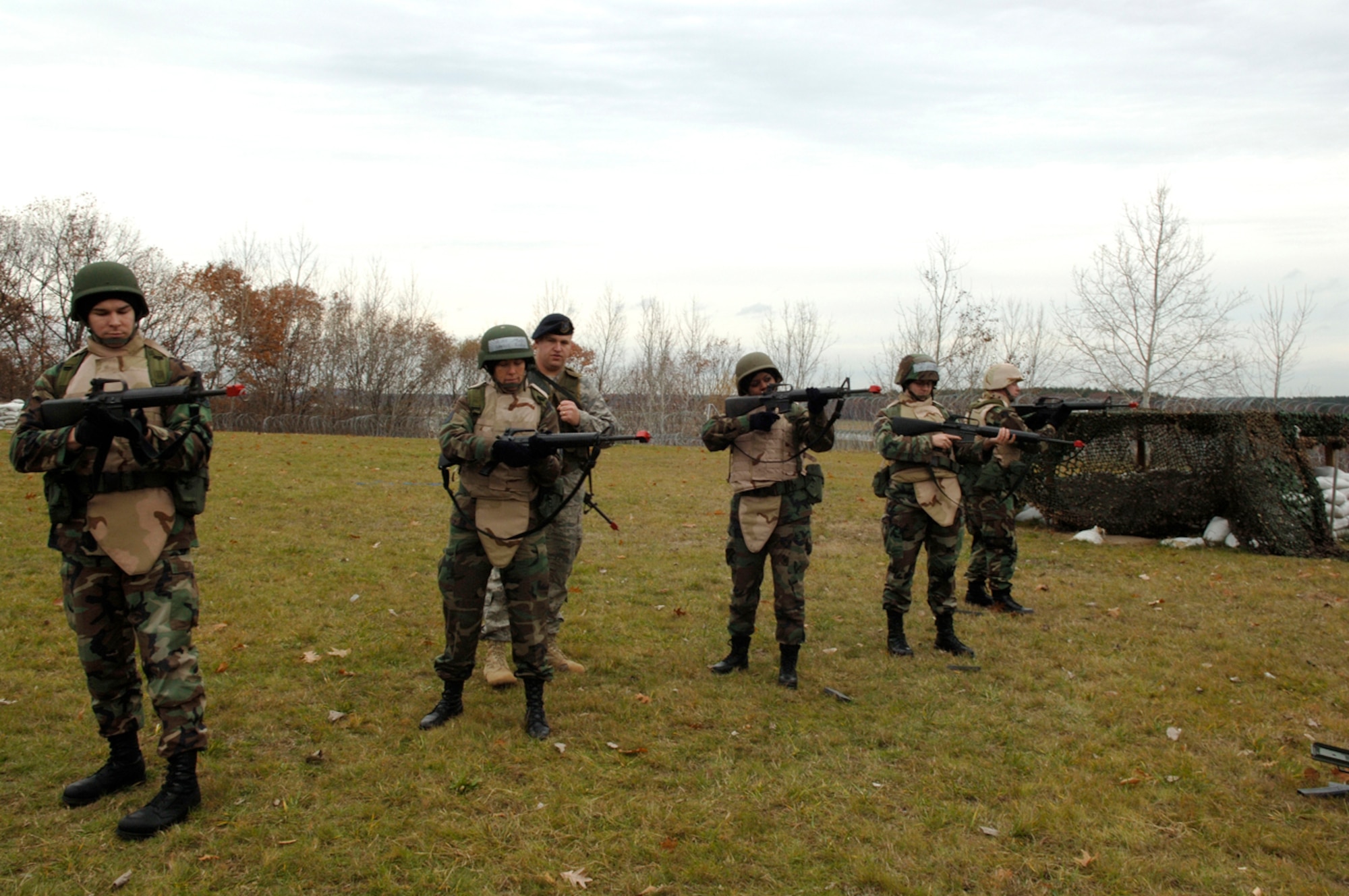 HANSCOM AFB, Mass. -- Expeditionary Airman Combat Skills trainees aim their M16 rifles during a weapons training session as the instructor, Senior Airman Matthew Medsger, 66th Security Forces Squadron (third from left), looks on. (U.S. Air Force photo by Jan Abate)