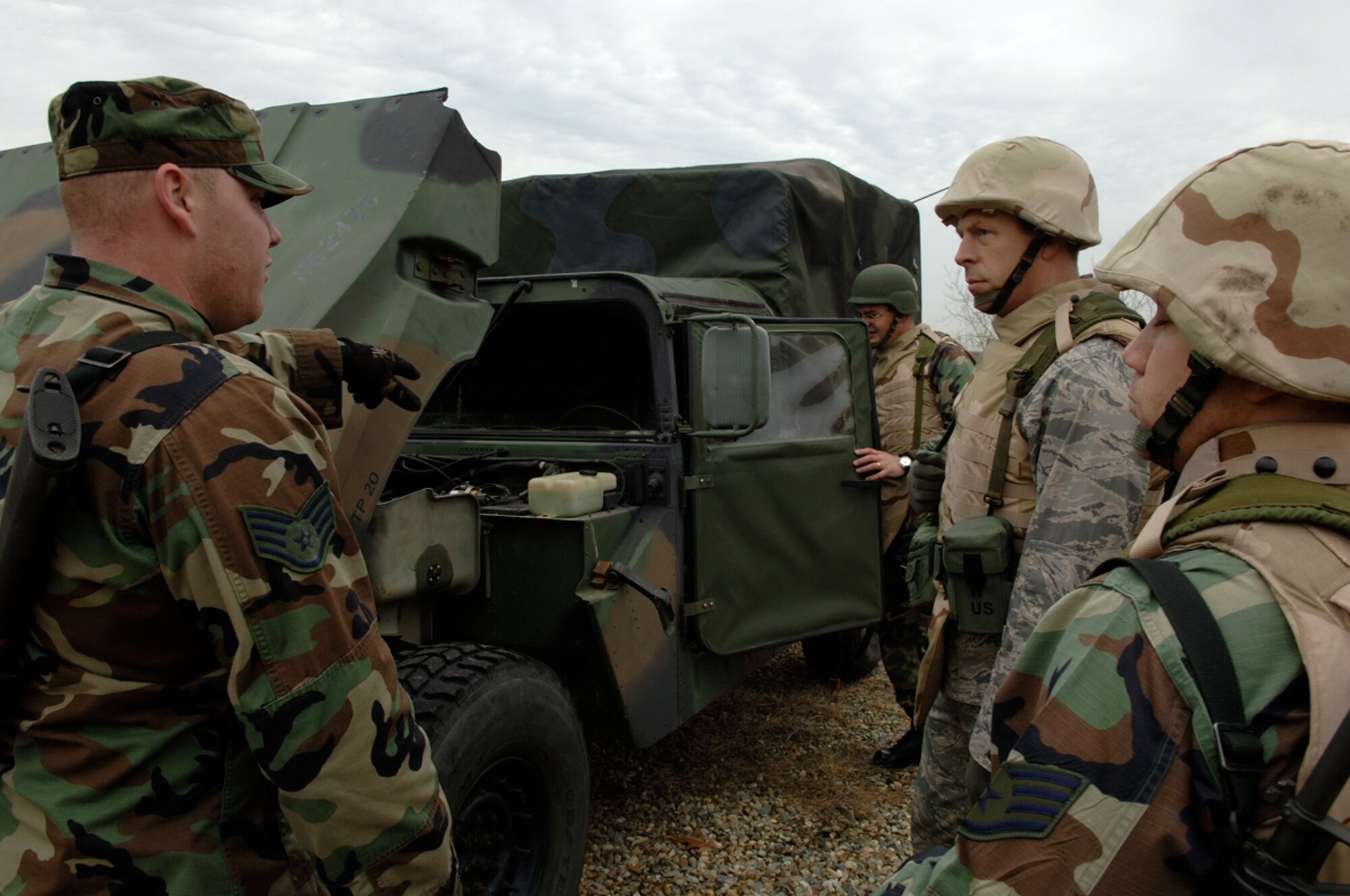 HANSCOM AFB, Mass. -- Staff Sgt. Christopher Hladky, 66th Comptroller Squadron (far right), and Maj. Brian Griffith, Air Force Research Laboratory, listen as Staff Sgt. Jason Matylewicz, 66th Security Forces Squadron (left), conducts a combat convoy operations training session at Camp Patriot Nov. 29, as part of Hanscom’s Expeditionary Airman Combat Skills training. (U.S. Air Force photo by Jan Abate)