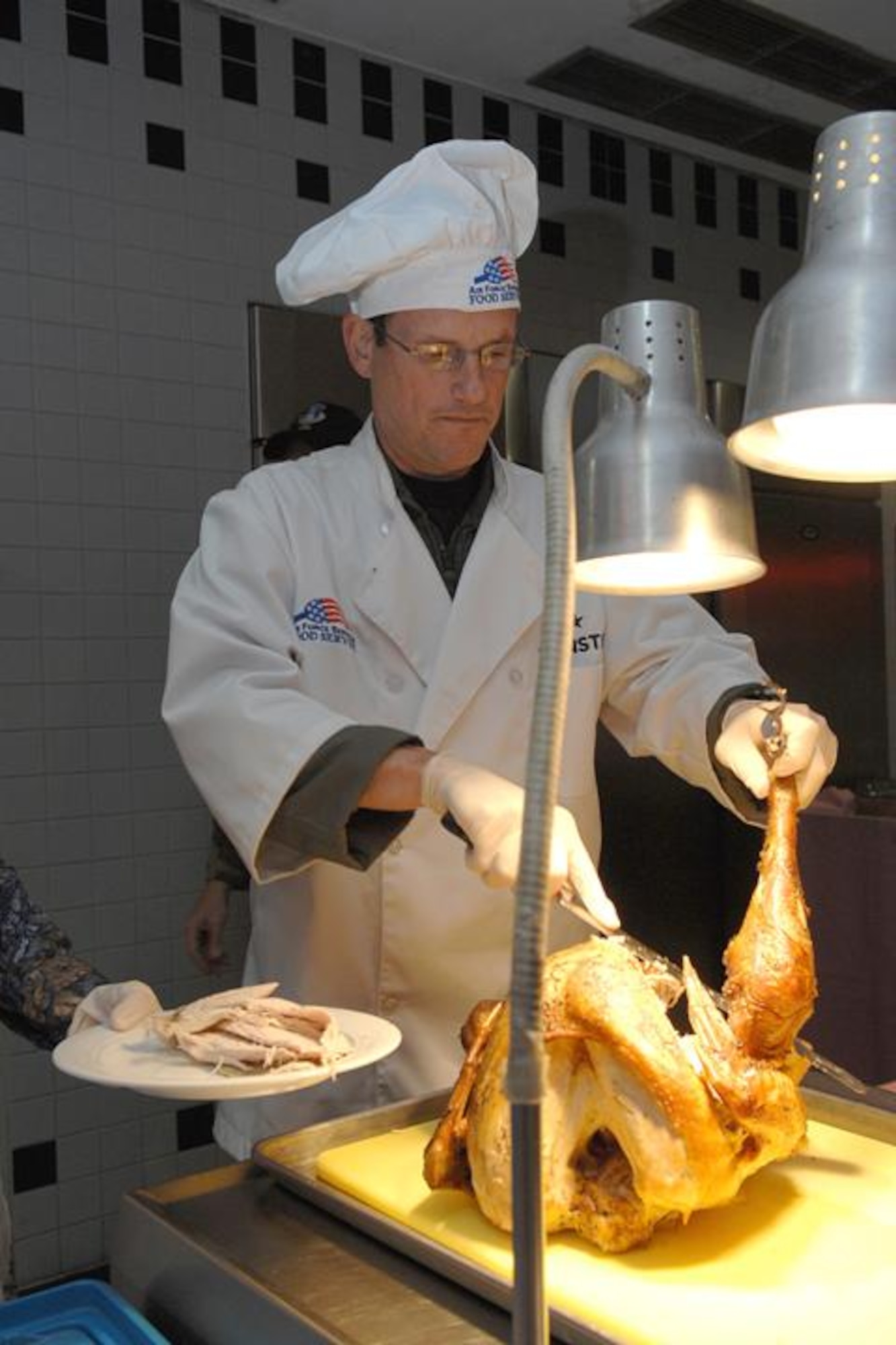 Brig. Gen. Rich Johnston, KMC and 86th Airlift Wing commander, carves the turkey at the Rheinland Inn Dining Facility on Thanksgiving day. (Photo by Staff Sgt. Rasheen Douglas)

