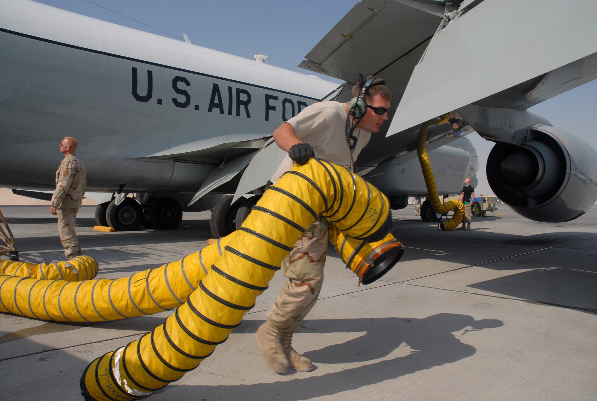 SOUTHWEST ASIA - Staff Sgt. Kelly Dejong, 379th Expeditionary Aircraft Maintenance Squadron drags air conditioning ducting from a RC-135 aircraft as he helps ready it for take off Dec. 4. Sergeant Dejong is deployed from Offutt AFB, Neb., and his hometown is Mitchell, S.D.  (U. S. Air Force photo/Staff Sgt. Douglas Olsen)