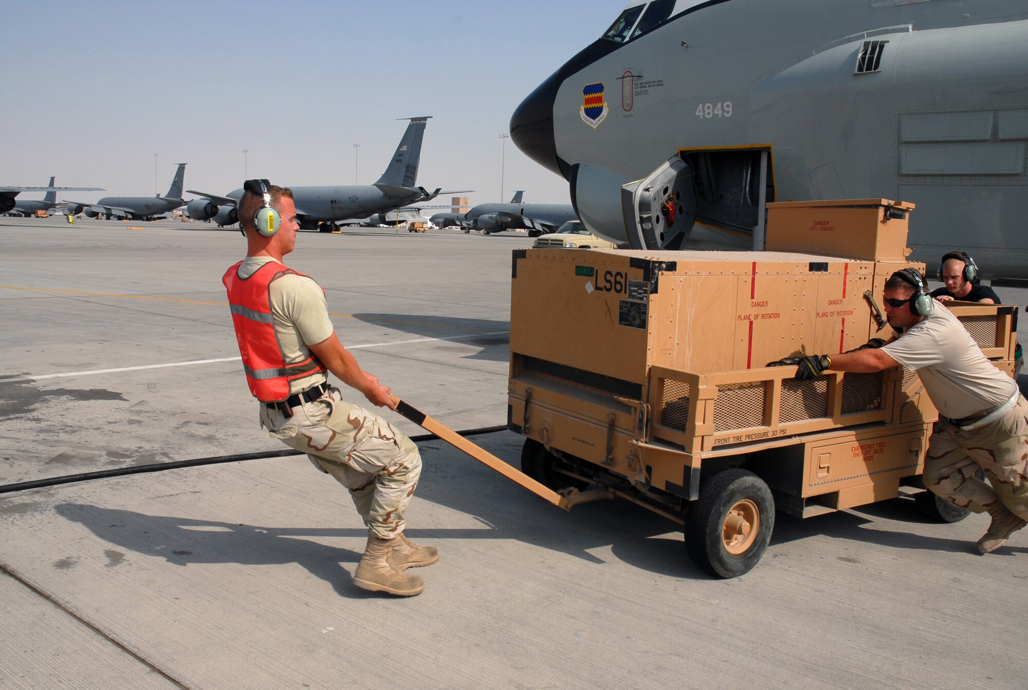SOUTHWEST ASIA -  Senior Airman Mark Butterfield, Staff Sgt. Kelly DeJong and Airman 1st Class Kenneth Smith, 379th Expeditionary Aircraft Maintenace Squadron, move the air cart away from a RC-135 aircraft in preparation for take off Dec. 4. The three airmen are deployed to a Southwest Asia air base from Offutt Air Force Base, Neb.  (U. S. Air Force photo/Staff Sgt. Douglas Olsen)