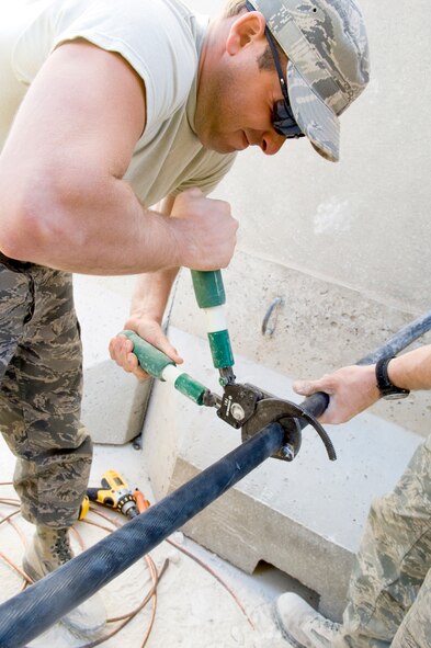 AL ASAD AIR BASE, Iraq -- Senior Airman Jonathan Zeggler, a 557th Expeditionary REDHORSE electrician, cuts a power cable to specifications to install in one of the newly-constructed convoy briefing rooms here. Airman Zeggler is deployed from Barksdale Air Force Base, La. (U.S. Air Force photo/Staff Sgt. Travis Edwards)