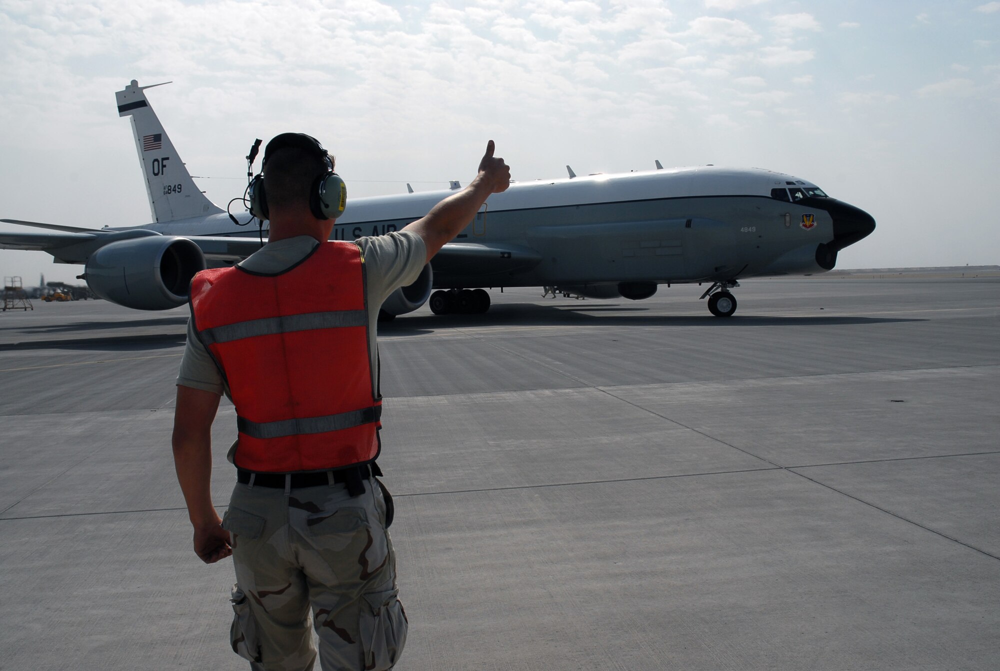SOUTHWEST ASIA - Airman 1st Class Mark Butterfield, 379th Expeditionary Aircraft Maintenance Squadron gives the aircraft pilot of a RC-135 'Thumbs up' for take off as it taxis towards the runway Dec. 4 at a base in Southwest Asia. Airman Butterfield is deployed from Offutt AFB, Neb., and his hometown is Syracuse, N. Y. (U. S. Air Force photo/Staff Sgt. Douglas Olsen)