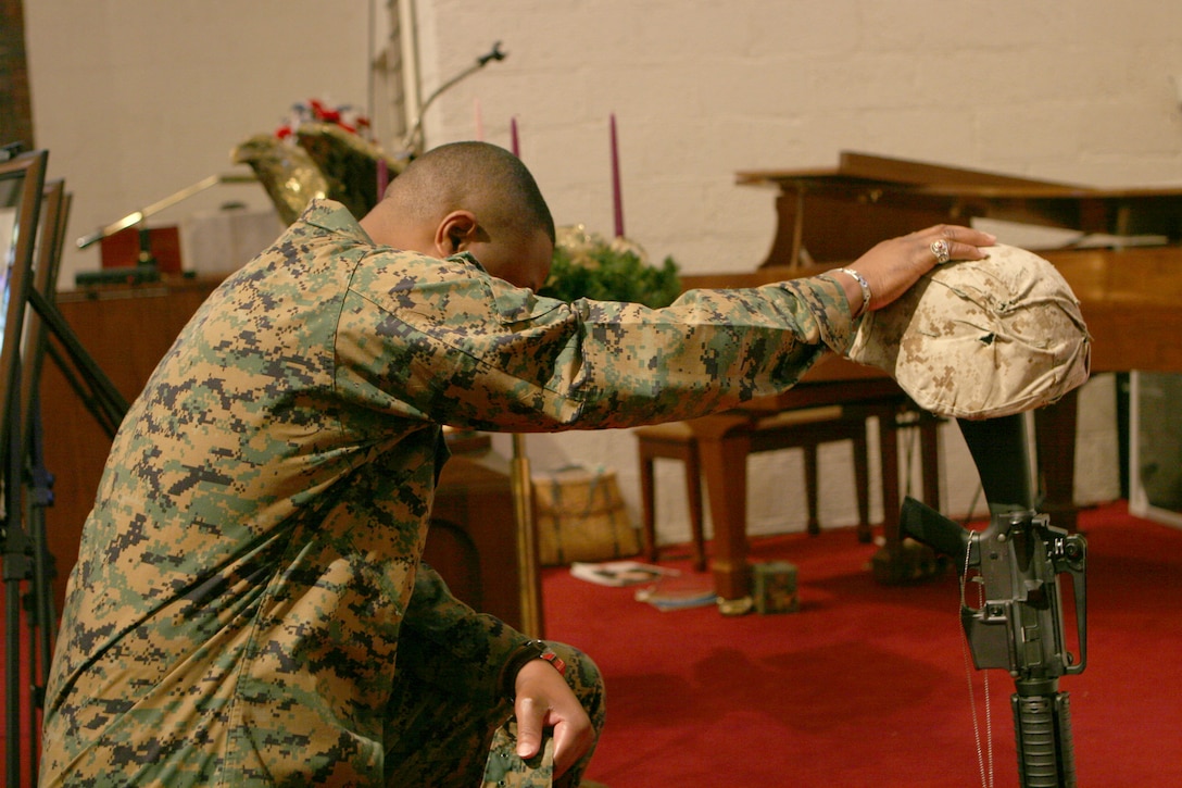 A Marine from 2nd Assault Amphibian Battalion, 2nd Marine Division, II Marine Expeditionary Force, pays his final respects to four fallen Marines during the battalion?s memorial service at the Protestant Chapel here Dec. 6. The Marines honored in the ceremony were Cpl. Christopher R. Degiovine, assault amphibian vehicle crewman, Company A; Cpl. Derek C. Dixon, a data technician with Co. A; Cpl. Willie P. Celestine; a radio operator with Co. A; and Cpl. Reynold J. Armand, a food service specialist with Headquarters & Service Company. They all gave their lives in support of Operation Iraqi Freedom. (Official Marine Corps Photo by Lance Cpl. Christopher Zahn) (Released)